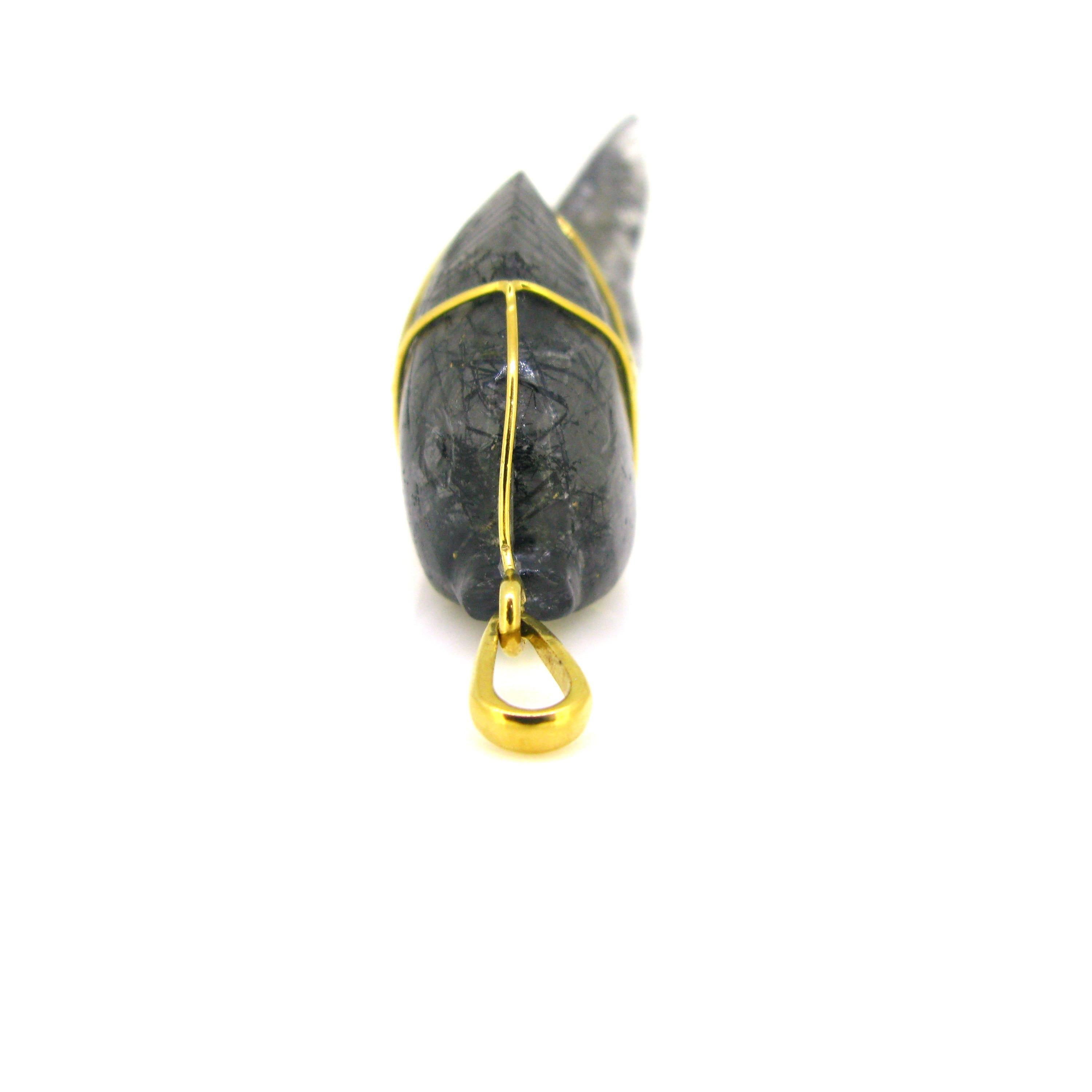 This beautiful and unusual crystal combines two gemstones: Quartz Crystal and Black Tourmaline. It was nicely engraved into a fish. It is hold by a 18kt yellow gold wire. The bale is signed Jean Été, a famous French design during the Seventies. It