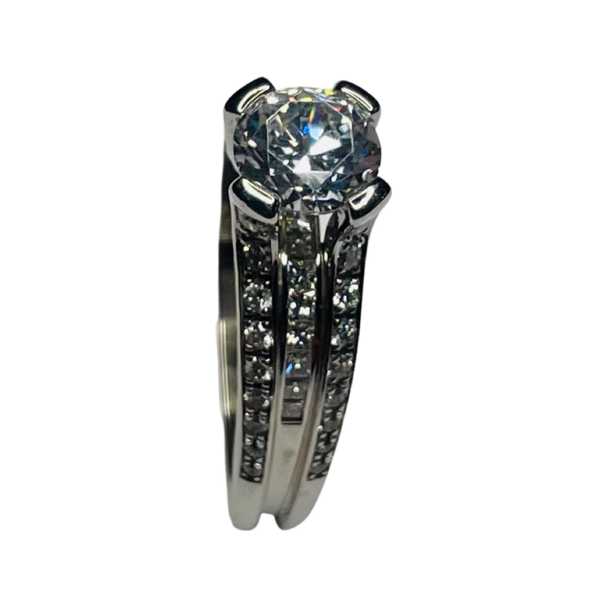Jean-François Albert  18K Weißgold Diamant Verlobungsring. Der Mittelstein ist ein 6,5 mm großer kubischer Zirkon. Er entspricht einem Diamanten von 1 Karat. Gegen einen Aufpreis kann er durch einen farbigen Stein, einen Moissonit oder einen