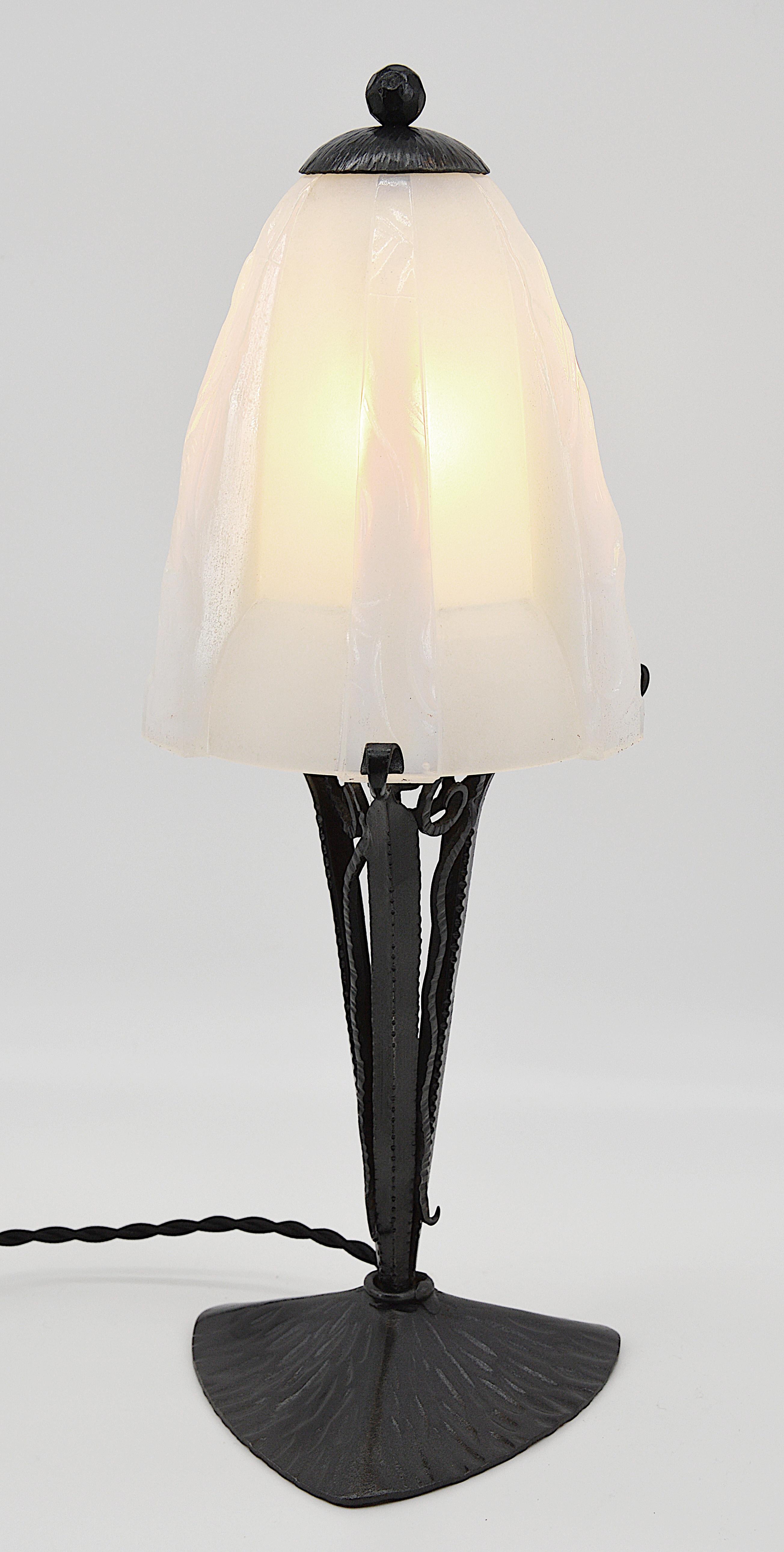 Lámpara de sobremesa francesa Art Déco de Jean Gauthier (París), Francia, años 1920. Tulipa gruesa semicristalina con motivos Art Déco. Según la exposición a la luz, predomina ligeramente el azul opalescente. Base de hierro forjado. Mismo periodo