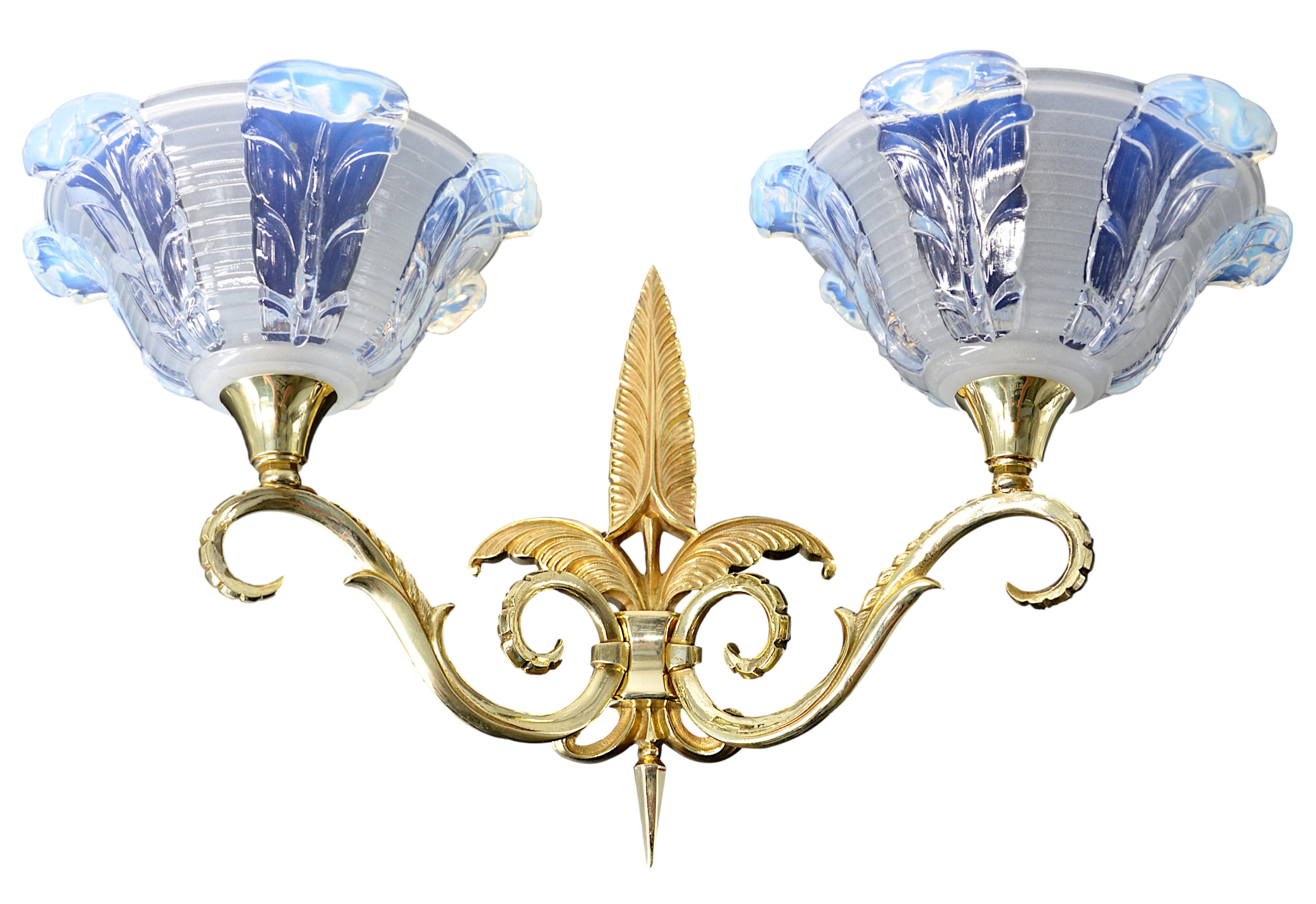 Juego francés Art Déco de 2 apliques dobles de Jean Gauthier, (París), Francia, años 20. Tulipa gruesa de vidrio moldeado opalescente (azul cobalto). Accesorios de bronce macizo. Medidas: Cada una: Alto 27,5 cm, ancho 47 cm, fondo 22 cm. Firma