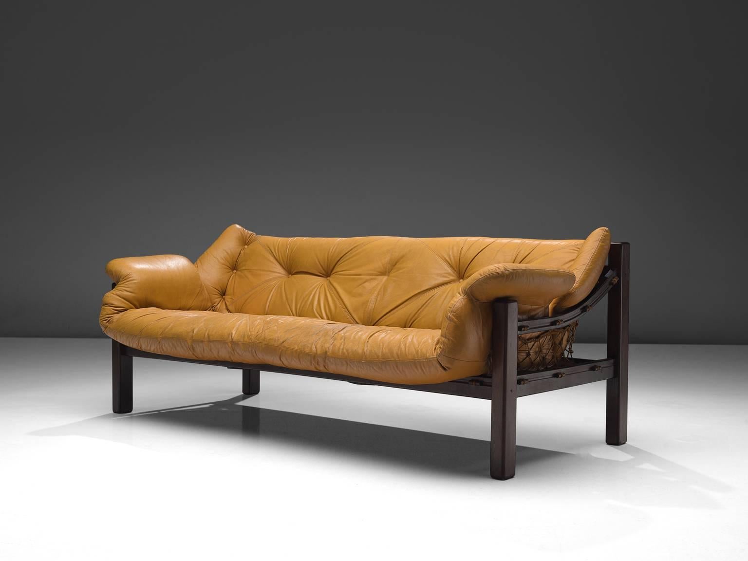 Jean Gillon for Italma, 'Amazonas' sofa, rosewood, yellow cognac leather, Brazil, 1968.

This robust and hefty sofa is designed by Jean Gillon. The originality of this Amazonas sofa comes from the concept of the body being captured by the piece of