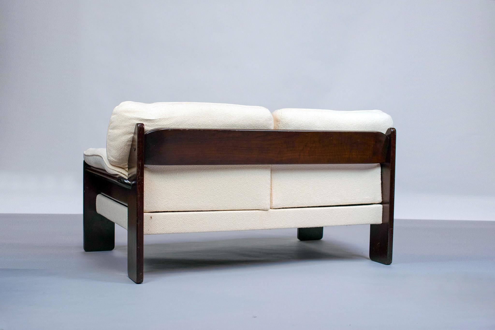 The 2-seater sofa designed by Brazilian designer Jean Gillon is an elegant and comfortable piece. It consists of a solid wood frame, covered with a white cotton curly fabric. The fabric is flexible and soft to the touch, offering an exceptional
