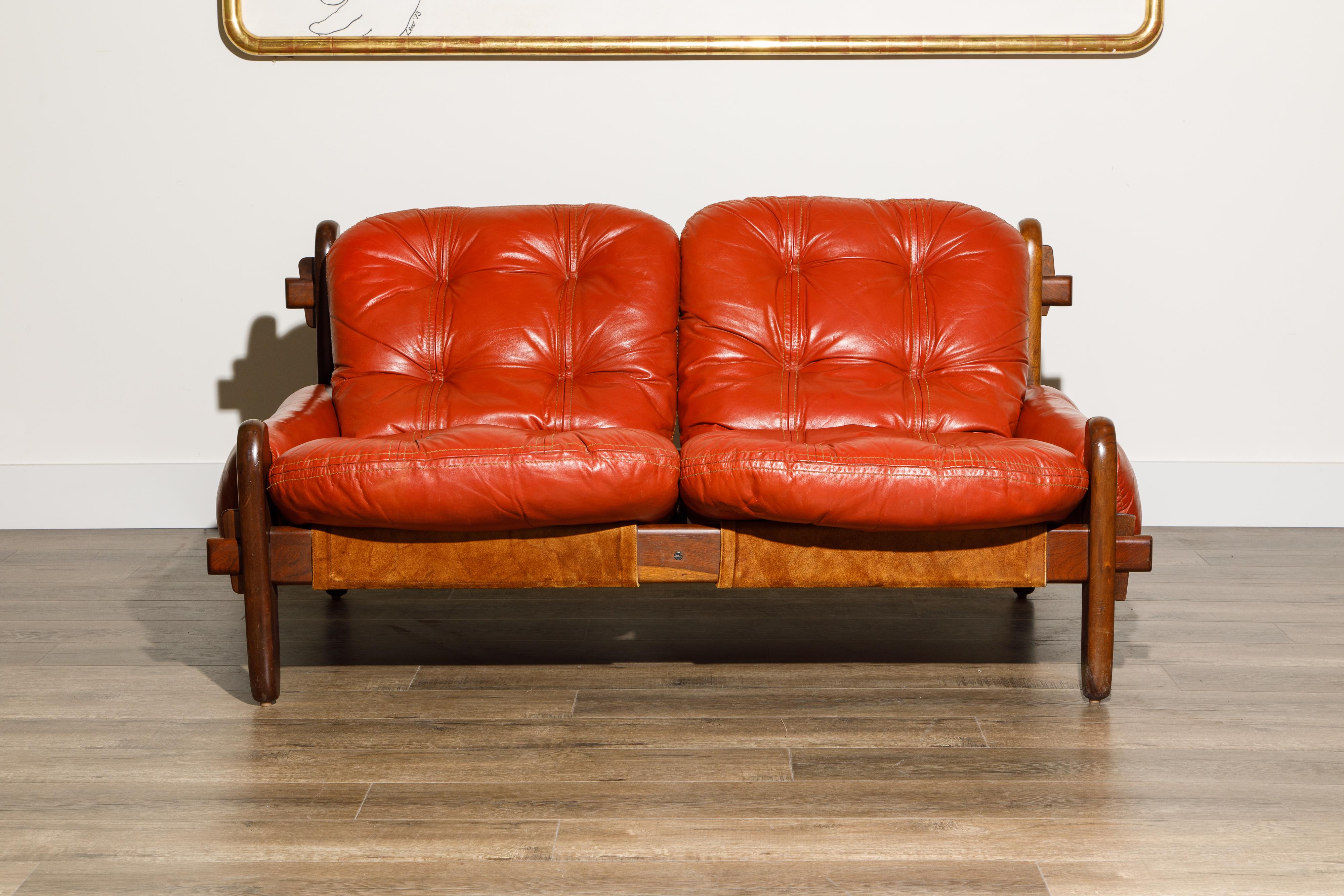 This rare Brazilian Modern collectors piece is by Jean Gillon for Probel and features gorgeous Brazilian Rosewood Jacaranda and beautiful red leather seats and arms.  Featuring natural leather slings which support the tufted seat cushions and