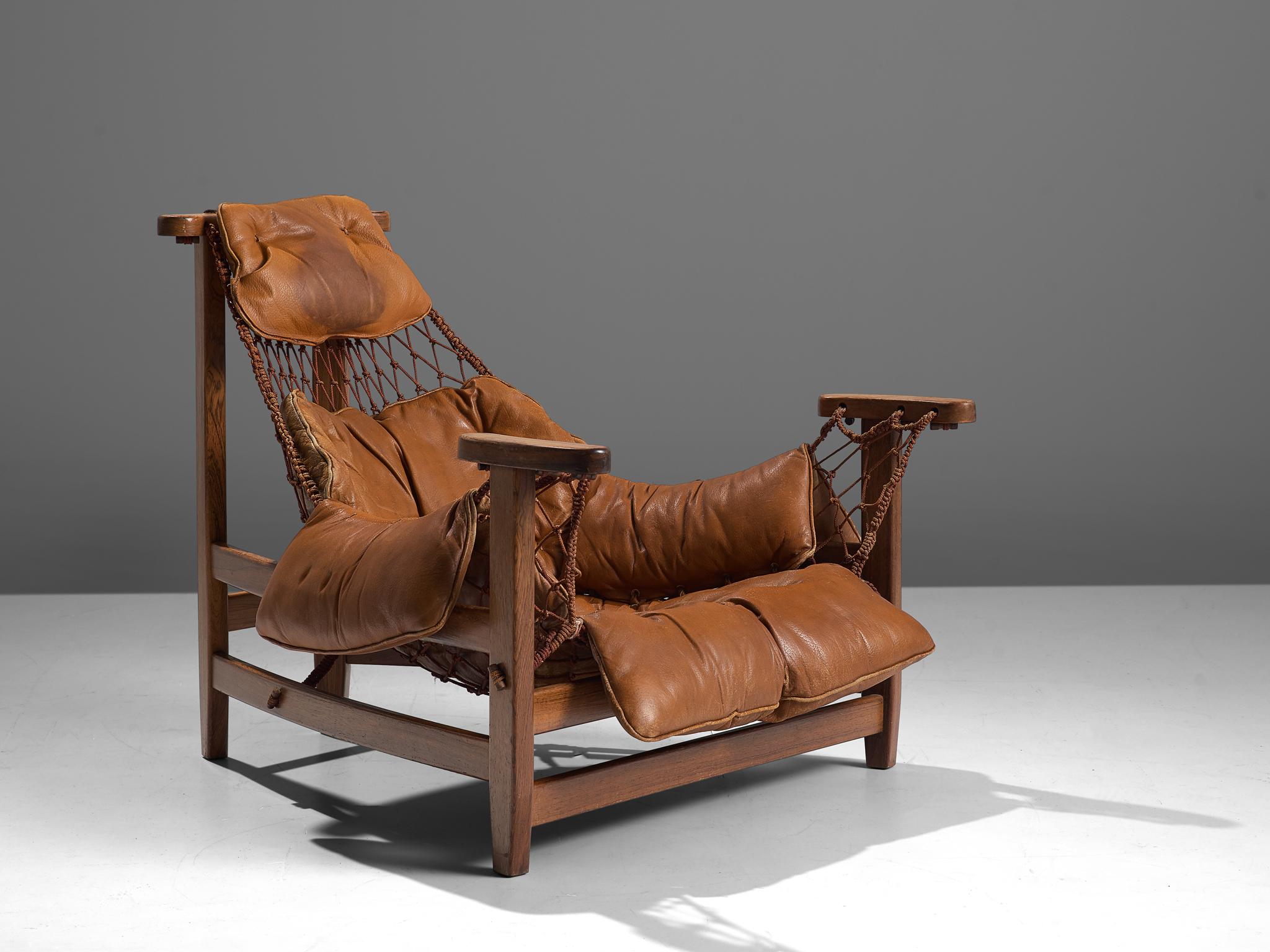 Jean Gillon, 'Jangada' armchair, rosewood, nylon rope, leather, Brazil, 1968.

This robust and hefty armchair is designed by Jean Gillon. The originality of this Jangada comes from the concept of the body being captured by the piece of furniture,