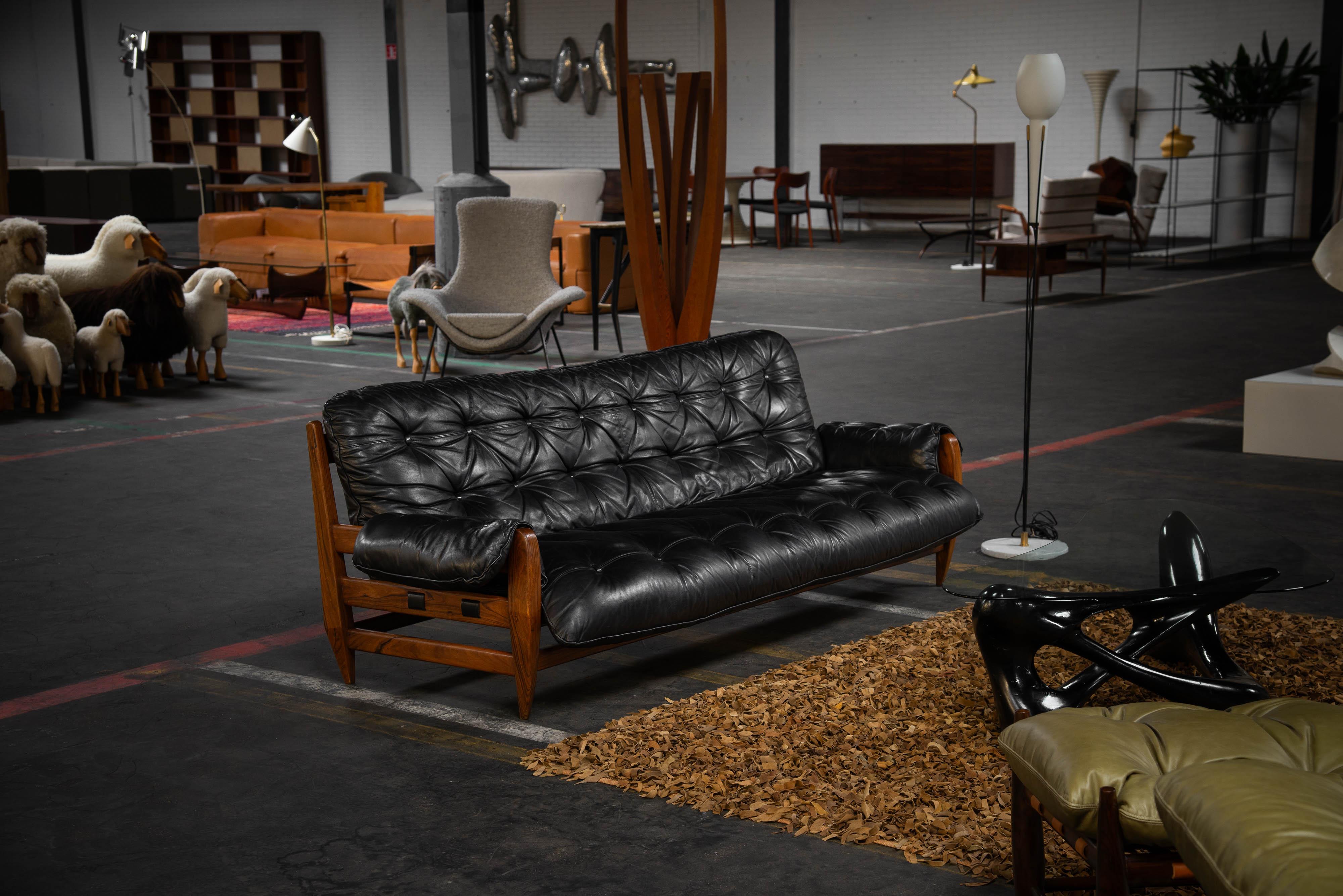 Typical Brazilian modern sofa model 'Rodeio' designed by Jean Gillon and manufactured by Italma Woodart, Brazil 1965. This sofa features a sturdy rosewood frame in a rich brown-red hue. The sofa consists of black padded leather cushions and back
