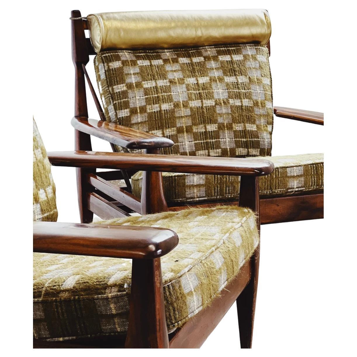 Rare pair of 1960s rosewood lounge chairs by Jean Gillon. Recovered in a Pierre Frey check wool, featuring green, blue and grey colors. Head rest in Italian metallic gold leather. Fabric in new condition, some scuff marks to the legs of the chair.