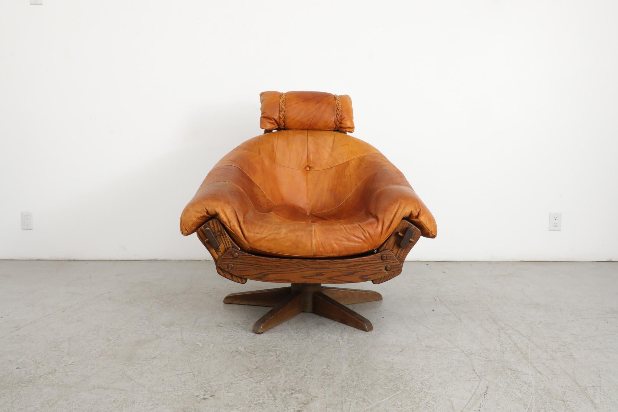 Magnifique fauteuil de salon pivotant de style Jean Gillon du milieu du siècle, avec coussins en cuir cognac sur un cadre en bois de chêne naturel de style Brutalist. Un salon remarquable et élégant, avec une belle patine et un motif de grain