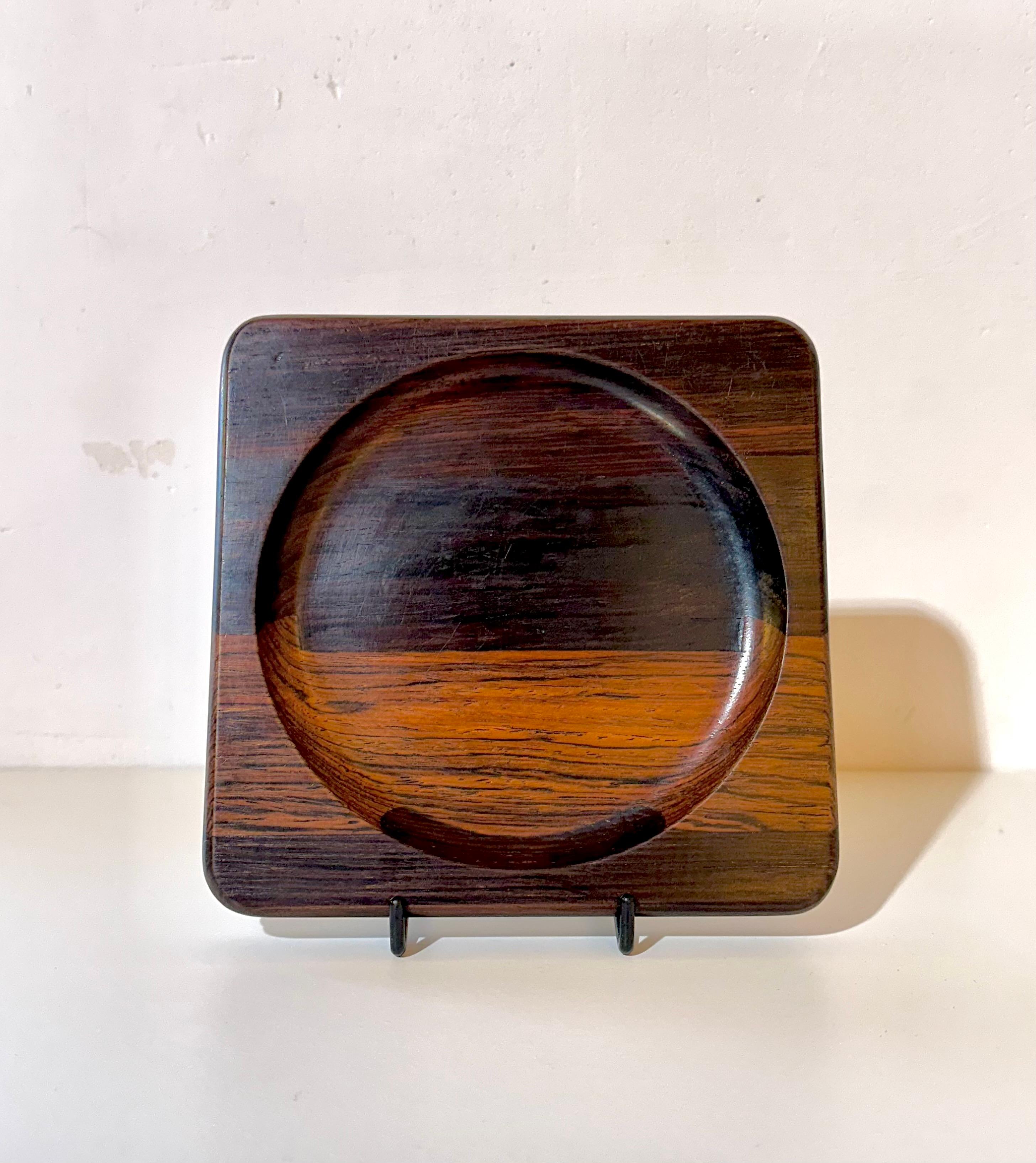 Suite von vier quadratischen Tabletts, entworfen von Jean Gillon, um 1960. Jede Platte hat die Maße 2 x 16 x 16 Zentimeter und bietet eine kompakte Größe und eine geometrische Form, die eine ausgewogene und zeitgenössische Ästhetik hervorruft.

Die