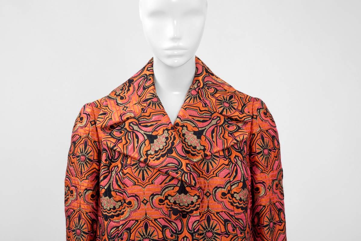 Opulent and richly textured, this sumptuous numbered (see picture 9) 60’s A-line haute couture coat is entirely made from orange, pink coral and black silk brocade, punctuated with gold lurex. Fully lined with a refined black silk, this coat