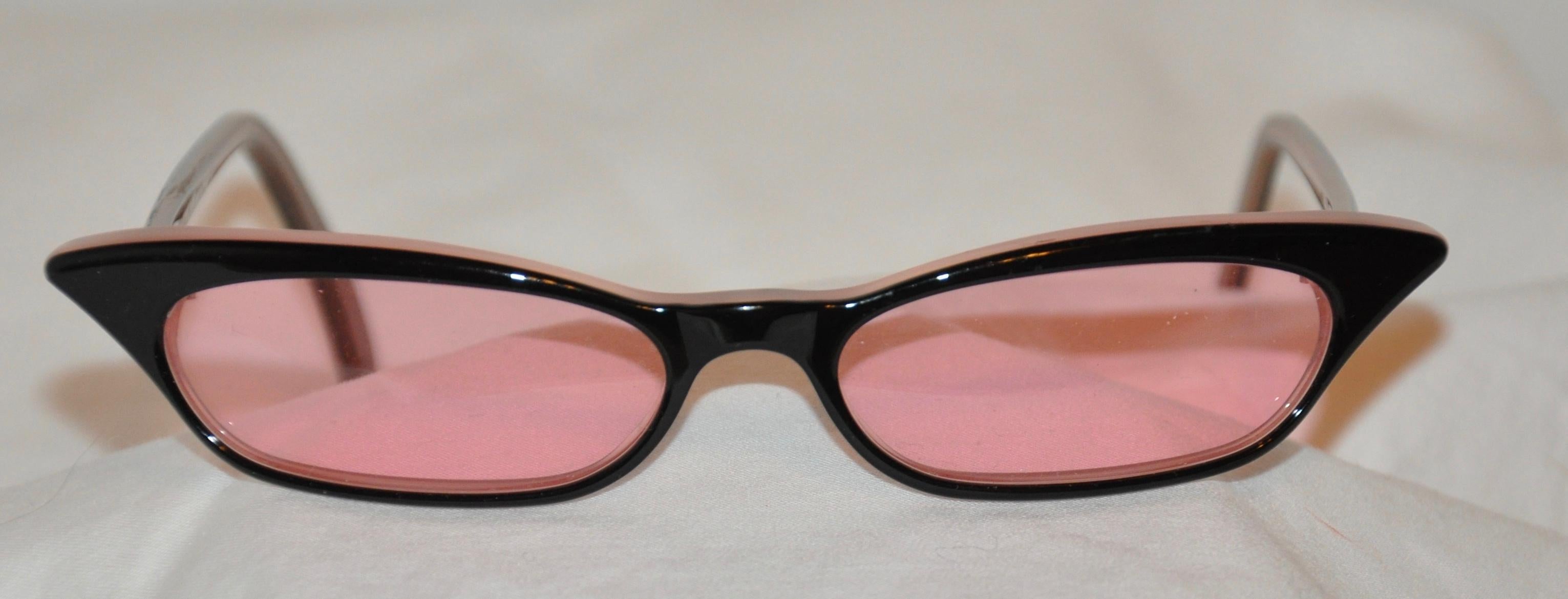 Jean Lafont beautifully elegant black and rose lucite 'Cat-Eye' styled frames are accented with rose-hue lens. Made in France, the front measures 5 3/8 inches across, height measures 1 inch, and the arms are 5 inches in length.