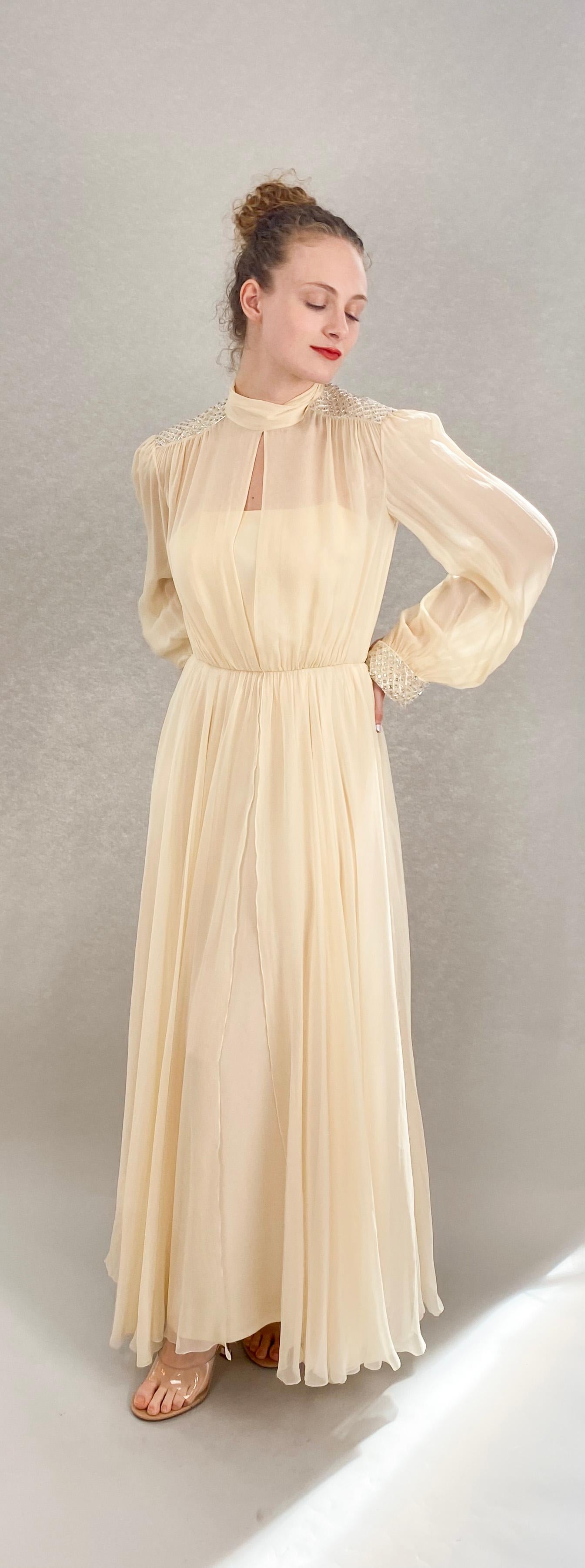 Indulge in luxury with the Jean Louis Ivory Silk Chiffon Beaded Shoulder Dress. Made with lightweight and flowy silk chiffon, this dress exudes elegance. The intricate beading on the shoulders adds a touch of sophistication, making you stand out at
