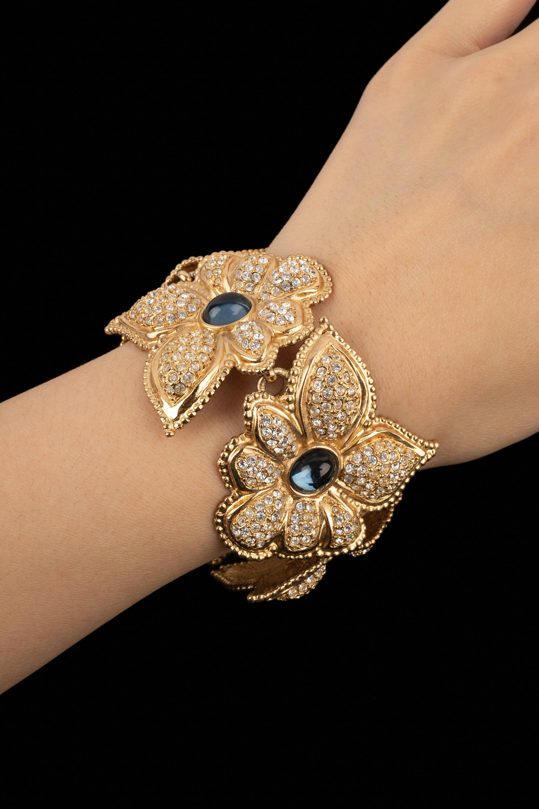 Jean-Louis Scherrer - (Made in France) Golden metal articulated bracelet ornamented with rhinestones and blue glass cabochons.

Additional information:
Condition: Very good condition
Dimensions: Length: 20 cm

Seller Reference: BRA138