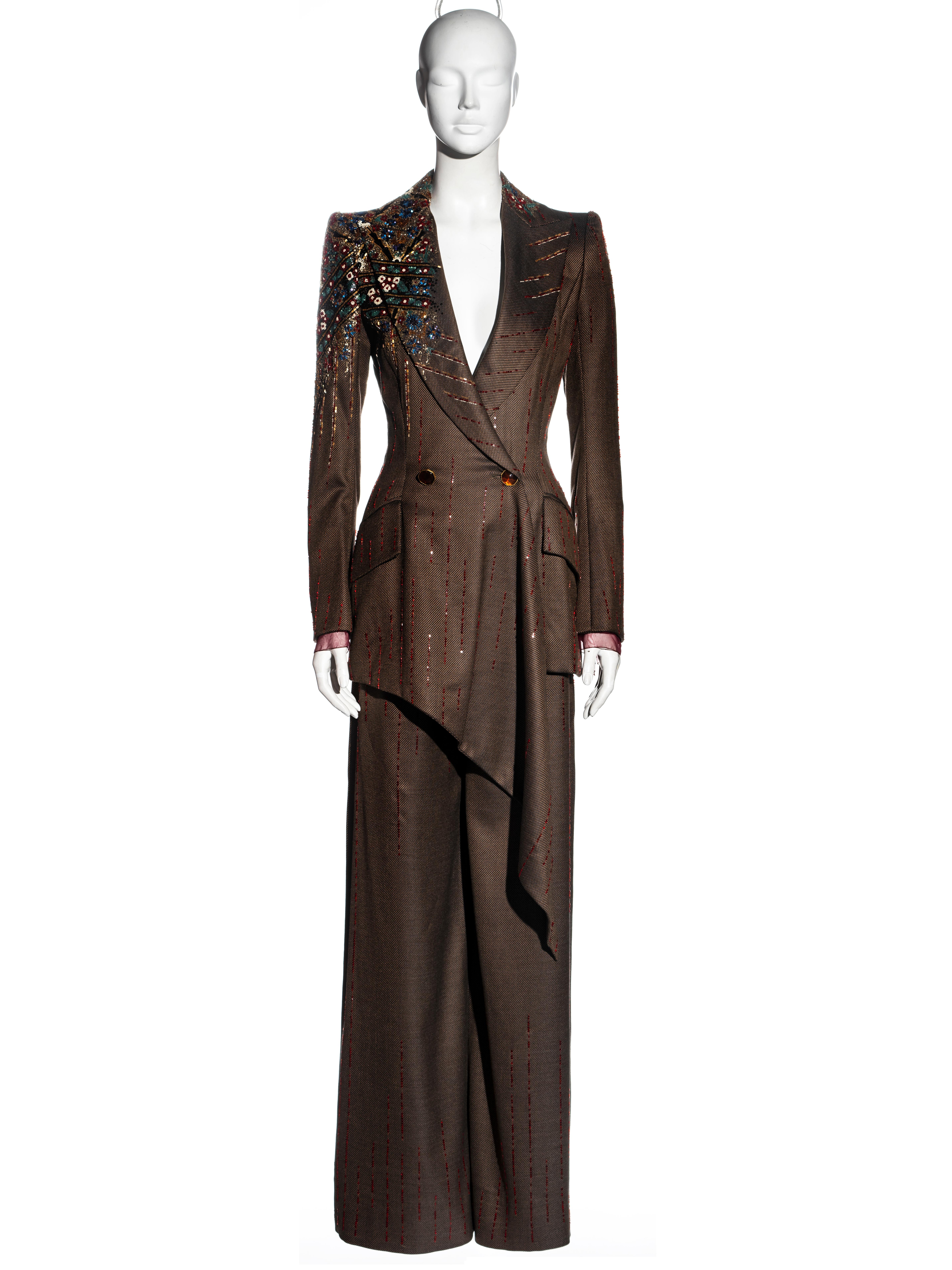 ▪ Jean-Louis Scherrer brown wool trouser suit
▪ Designed by Stephane Rolland 
▪ Double-breasted blazer jacket 
▪ Heavily beaded right shoulder
▪ Asymmetric hemline 
▪ Red beaded pinstripes 
▪ Large amber stone buttons
▪ Wide-leg pants
▪ Fall-Winter