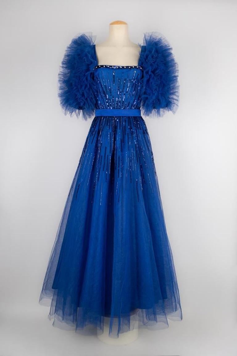 Louis Feraud - (Made in France) Big evening dress made of royal-blue tulle and satin. Bustier embroidered with blue sequins. Three-quarter length sleeves made of tulle flounces. No size nor composition label, it fits a 40FR.

Additional