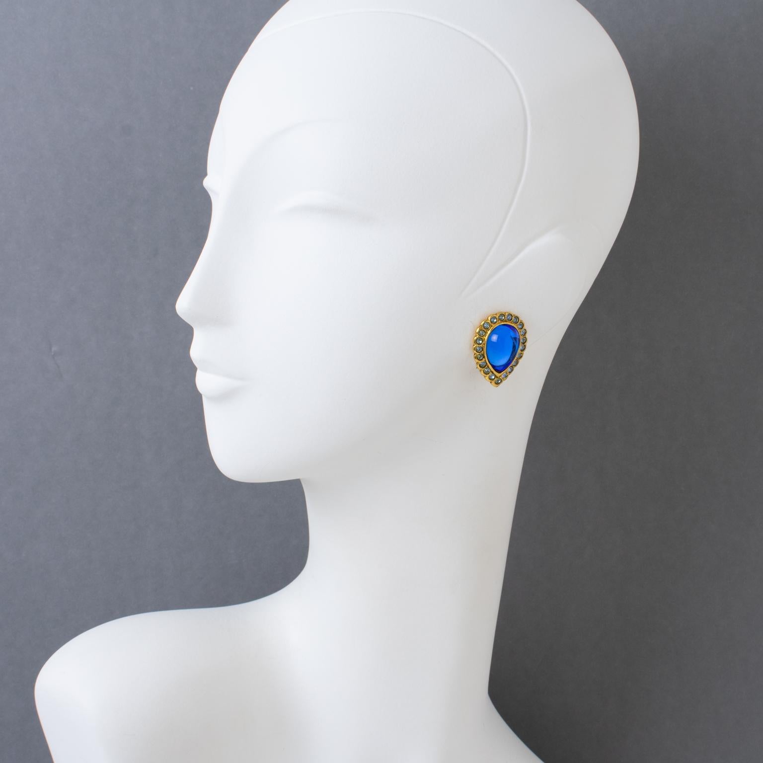These exquisite French designer Jean Louis Scherrer Paris clip-on earrings feature a geometric teardrop dimensional shape, with a gilded metal framing embellished with cobalt blue Gripoix poured glass cabochons and topped with baby blue crystal