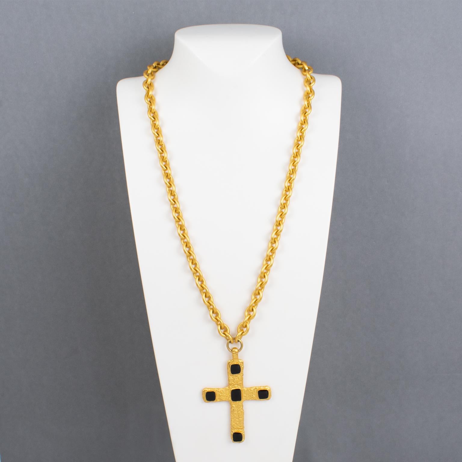 Jean Louis Scherrer Paris diseñó este impresionante collar con colgante de la década de 1980. Esta rara pieza ostenta una pesada cadena de metal dorado con acabado satinado, adornada con un colgante en forma de cruz. El colgante modernista en forma