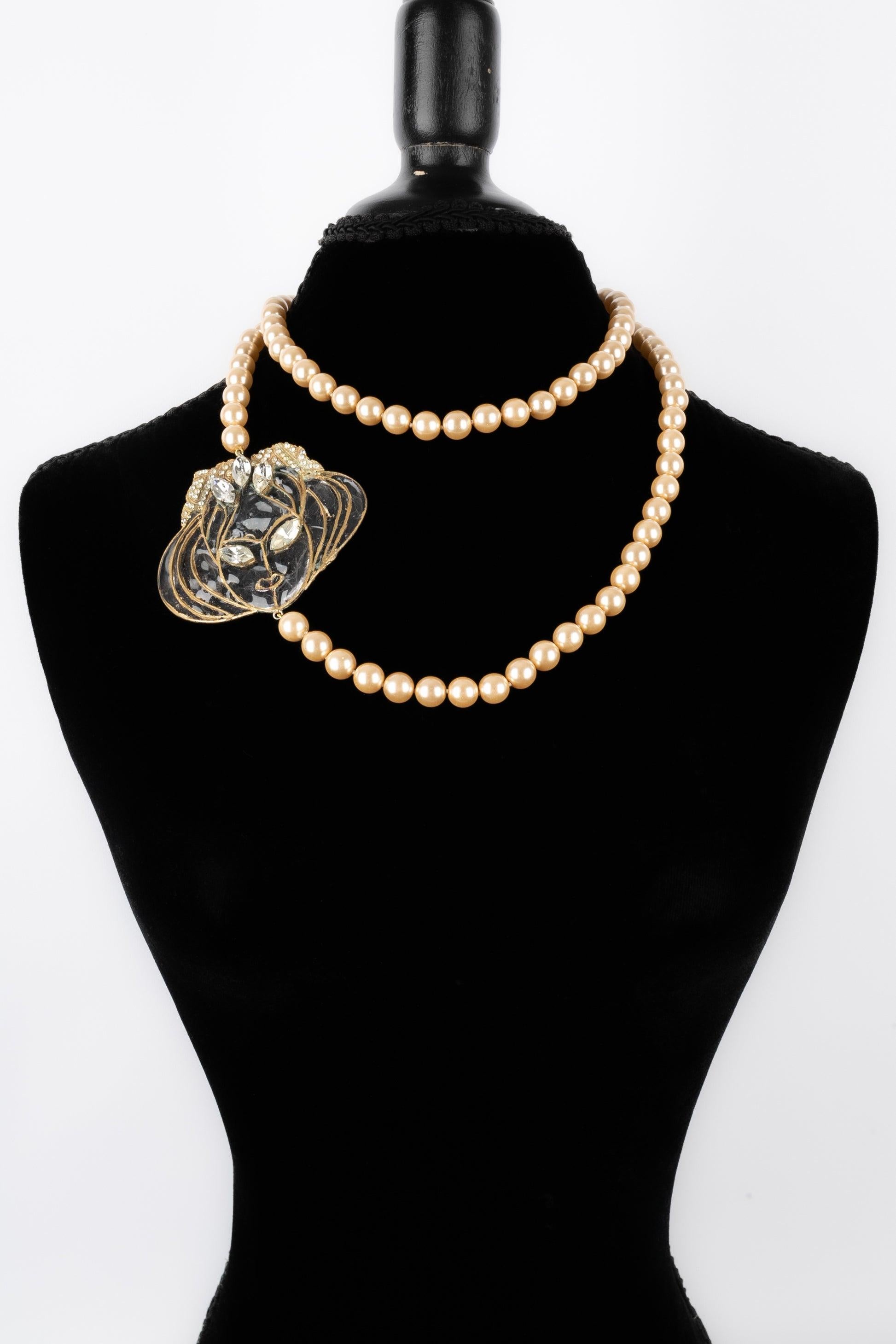 Jean-Louis Scherrer - Long costume pearl necklace assembled with knots, with a glass paste medallion representing a face. To be mentioned, some defects on the glass paste.

Additional information: 
Condition: Very good condition
Dimensions: Length: