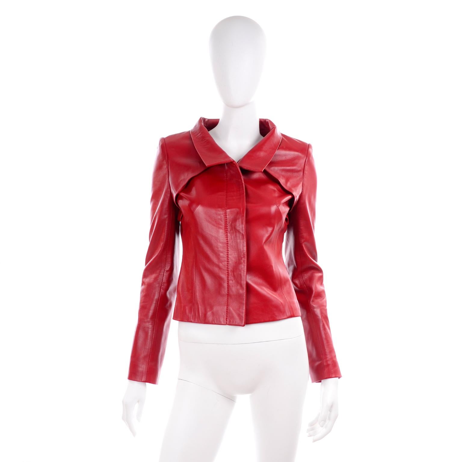 This is a gorgeous Jean Louis Scherrer cherry red lambskin leather jacket with unique pleating details. Designed during Stephane Rolland's time as artistic director of the brand. The jacket buttons up the front with red buttons covered with a