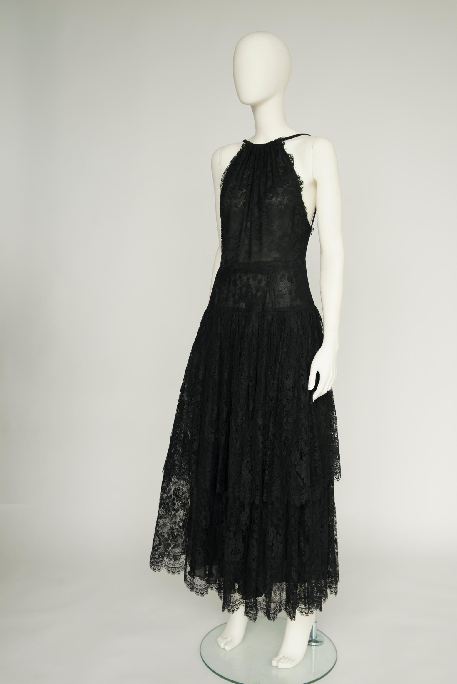 Elegant and alluring, this vintage Jean Louis Scherrer evening dress will undoubtedly be your best ally for many events to come !
Crafted from sheer black lace, it features a scalloped halter neckline (same scalloped details at the hem) and a