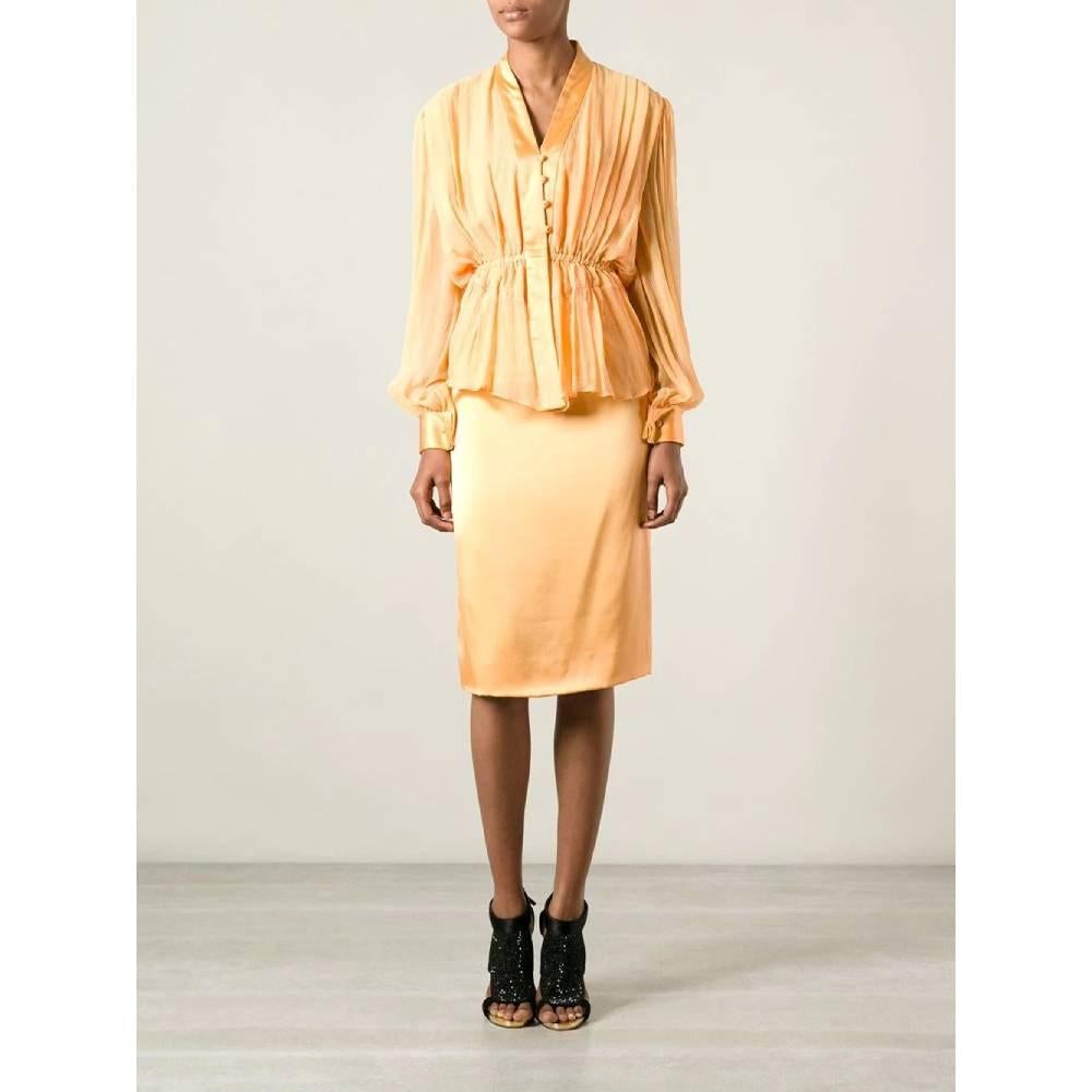 Jean Louis Scherrer 70s peach orange silk skirt suit. V-Neck shirt, long sleeves and front draped details. Rhinestones buttons fastening. High-waist pencil skirt with rear concealed zip fastening. Removable draped waistbelt.

Size: 38 FR

Flat