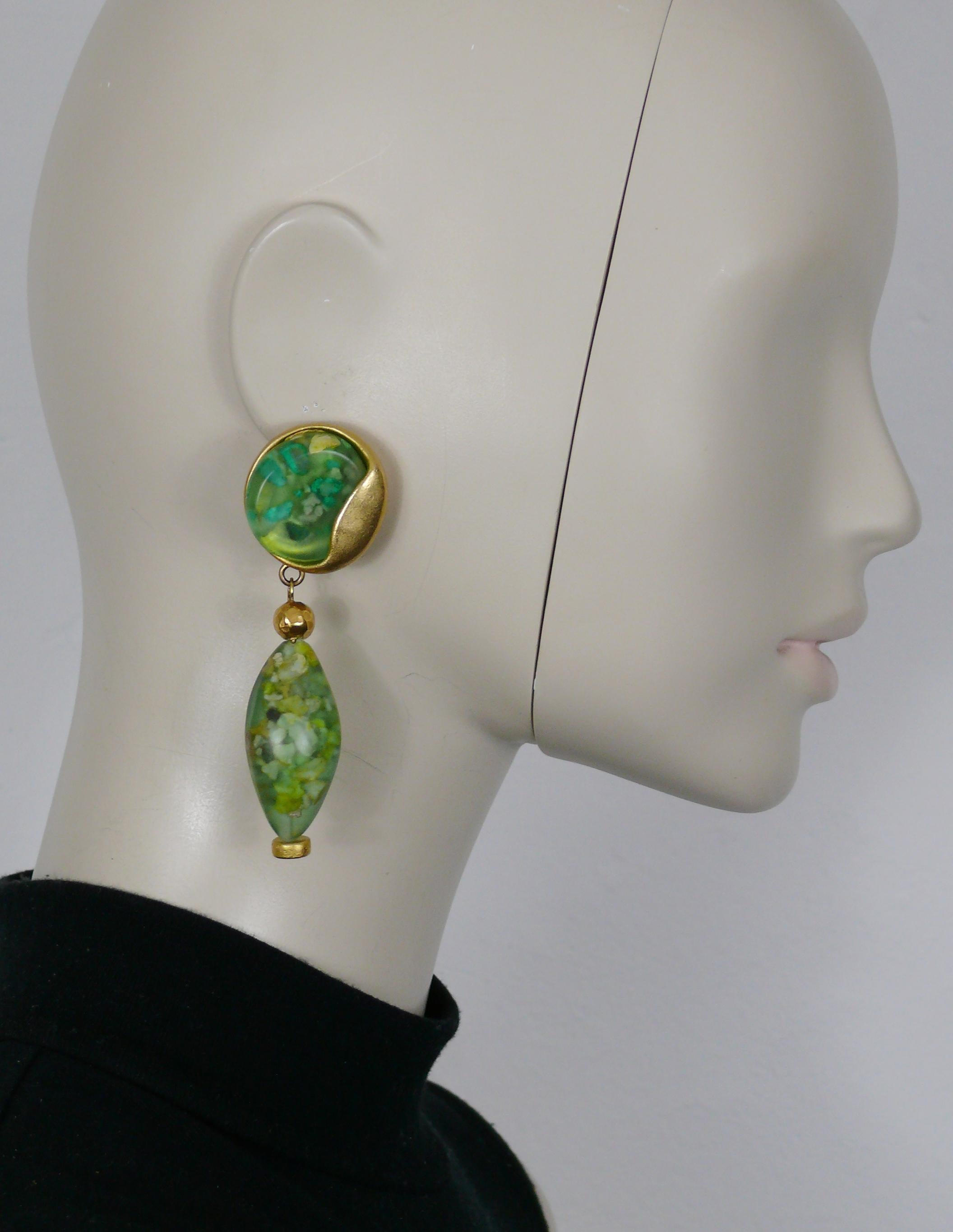 JEAN LOUIS SCHERRER vintage goldfarbene Ohrringe (Clip-on) mit grünen Harzelementen und Steineinlagen.

Gezeichnet SCHERRER Paris.

Ungefähre Maße: Höhe ca. 8,2 cm (3,23 Zoll) / max. Breite ca. 2,6 cm (1,02 Zoll).

Gewicht pro Ohrring: ca. 38