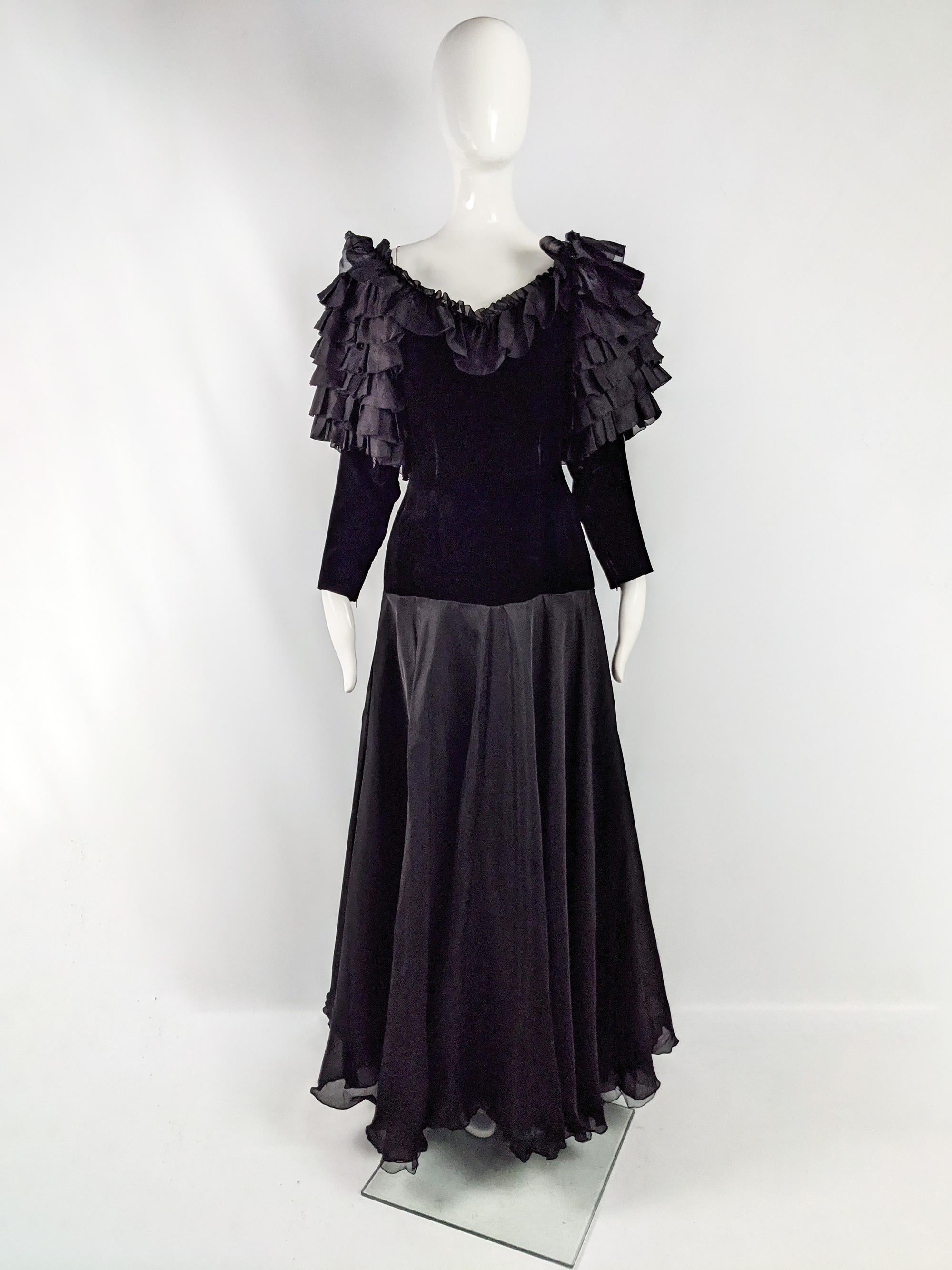 A breathtaking vintage full length, demi couture evening dress from the 80s by luxury French fashion designer, Jean Louis Scherrer. It has ruffled sleeves and a huge, full skirt. The long sleeved bodice is made of a sumptuous black velvet with