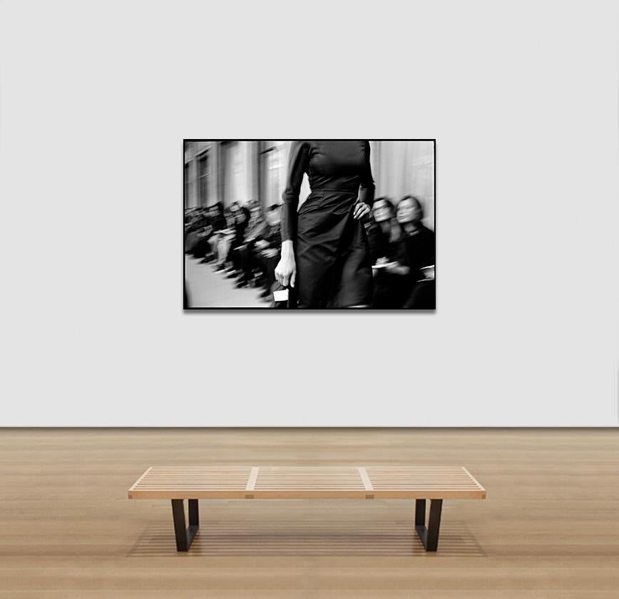 This is a 39.5 x 59 inches archival giclée black and white print on archival exhibition paper.  It is part of a limited edition of 6 plus 2 AP. Signed and numbered in the back.
It shows a close up of a model on the runway with the public in the