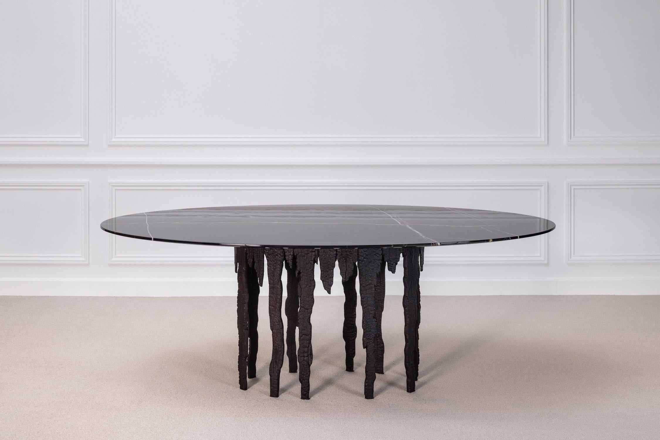 From his Empreinte Collection, a series of pieces centered around a theme of destruction and reconstruction, this exceptional table is composed of patinated bronze cast from broken and burned wooden planks. Crowned with a lush polished black Sahara