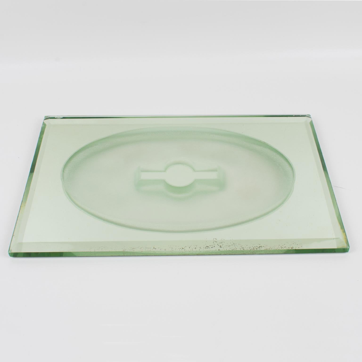This Art Deco mirrored tray, centerpiece, or platter was designed by French designer Jean Luce (1895 - 1964) in the 1930s. The thick mirrored glass slab has a sanded oval geometric motif in the center and deep beveling around it. The centerpiece