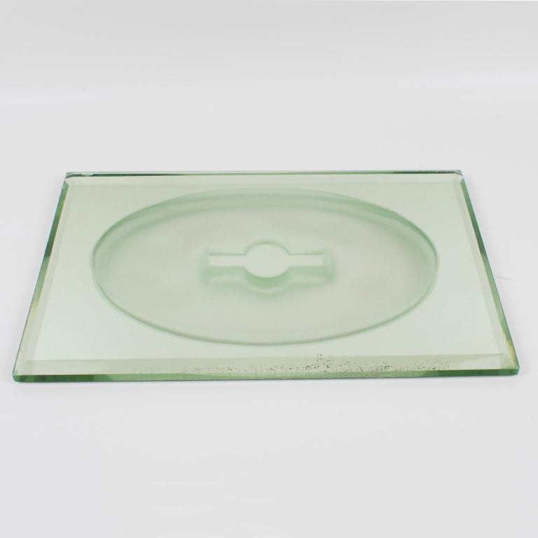 Stunning Art Deco mirrored tray, centerpiece, or platter by French designer Jean Luce (1895 - 1964), circa 1930. Thick mirrored glass slab with sanded ovoid geometric motif in the center and deep beveling all around. Classic green hue to vintage