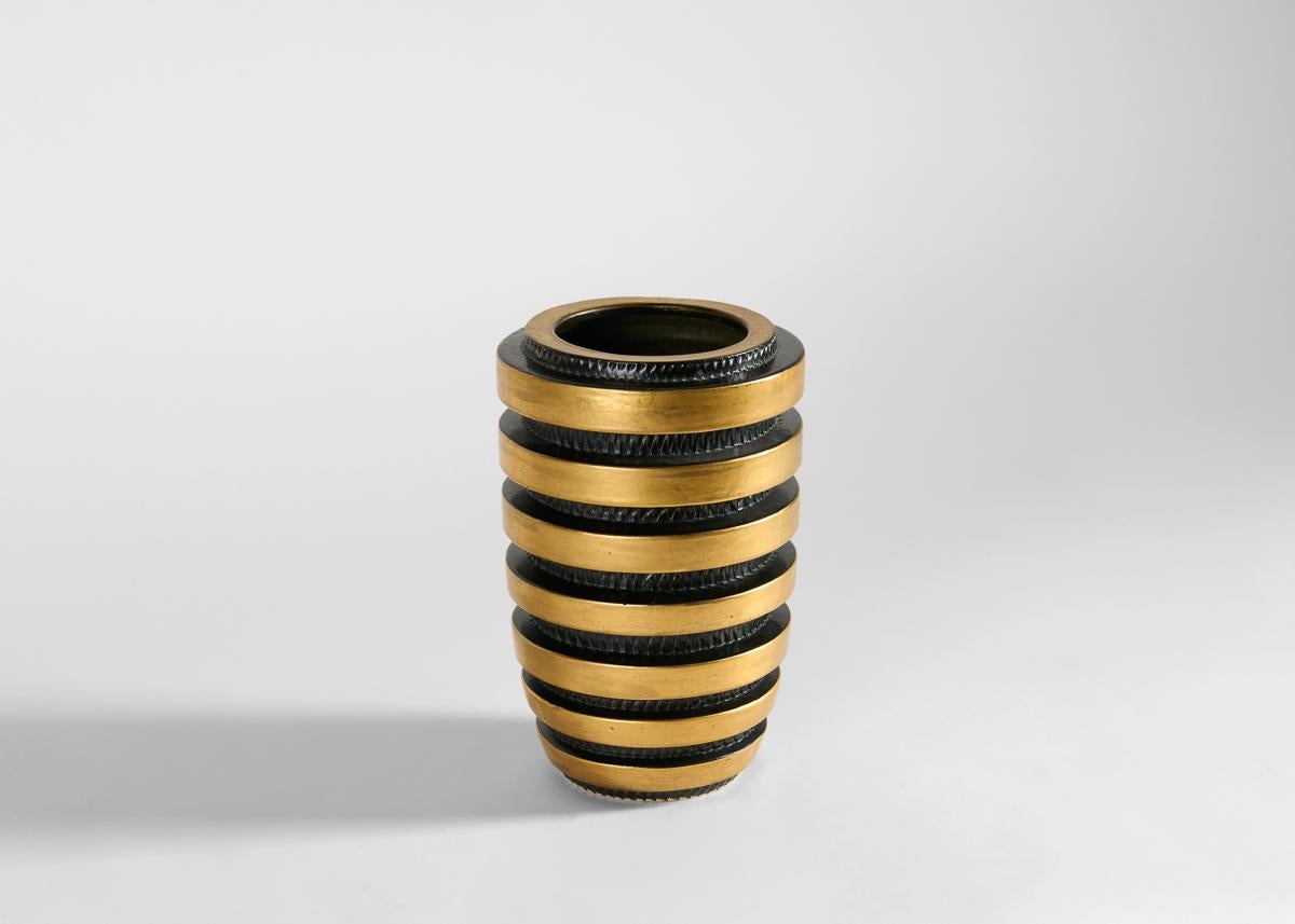 Known for his long career spanning a range of 20th Century movements, Jean Luce's Machine Age vase is ringed by gold bands, giving the impression that the vase has been mechanically sliced. Or perhaps, it evokes the famed character Bibendum, aka