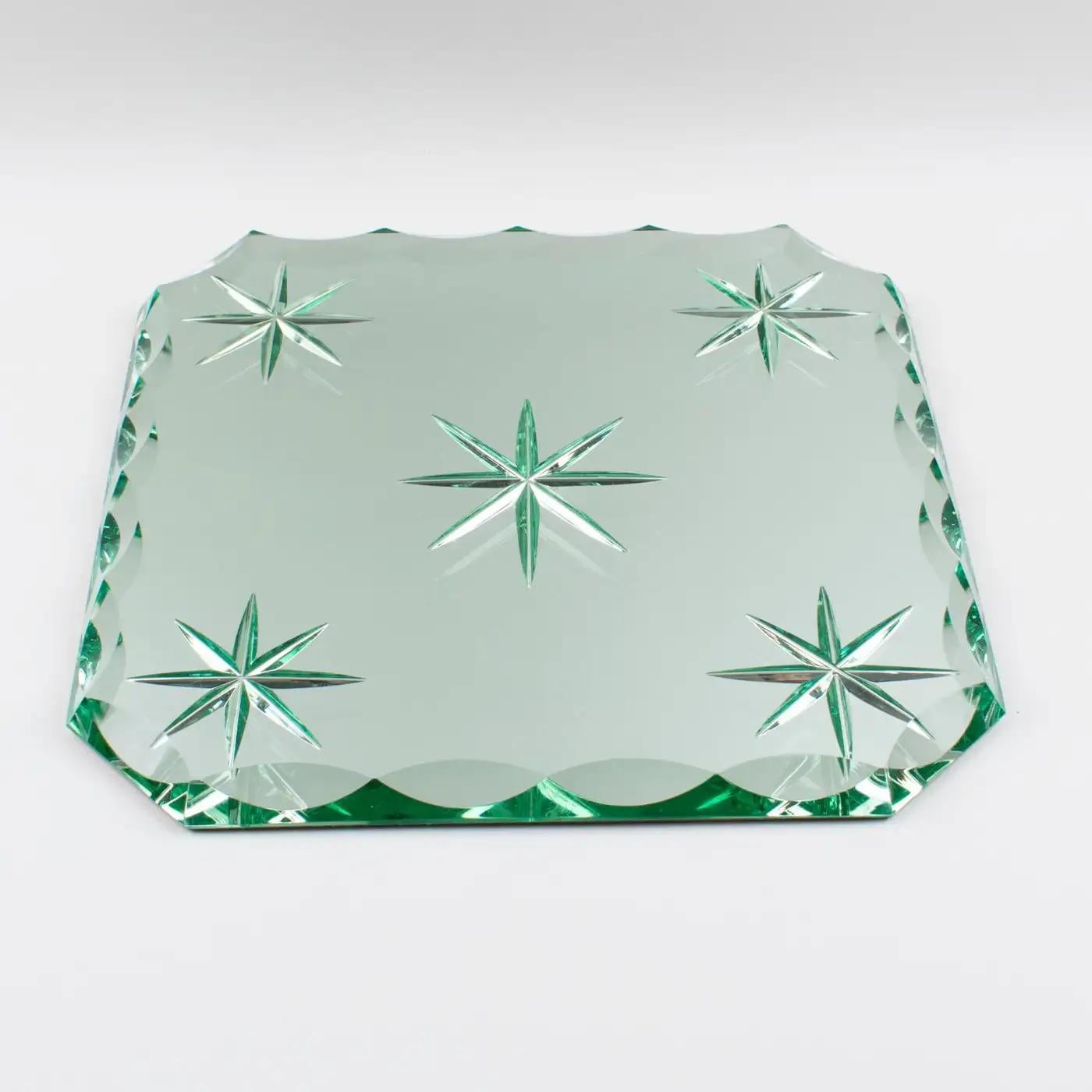 Le designer français Jean Luce (1895-1964) a créé ce ravissant plateau, centre de table ou plat en miroir de style Art déco. La dalle de verre miroir extra-épaisse a une forme carrée avec un motif gravé en étoile au centre, et les quatre angles et