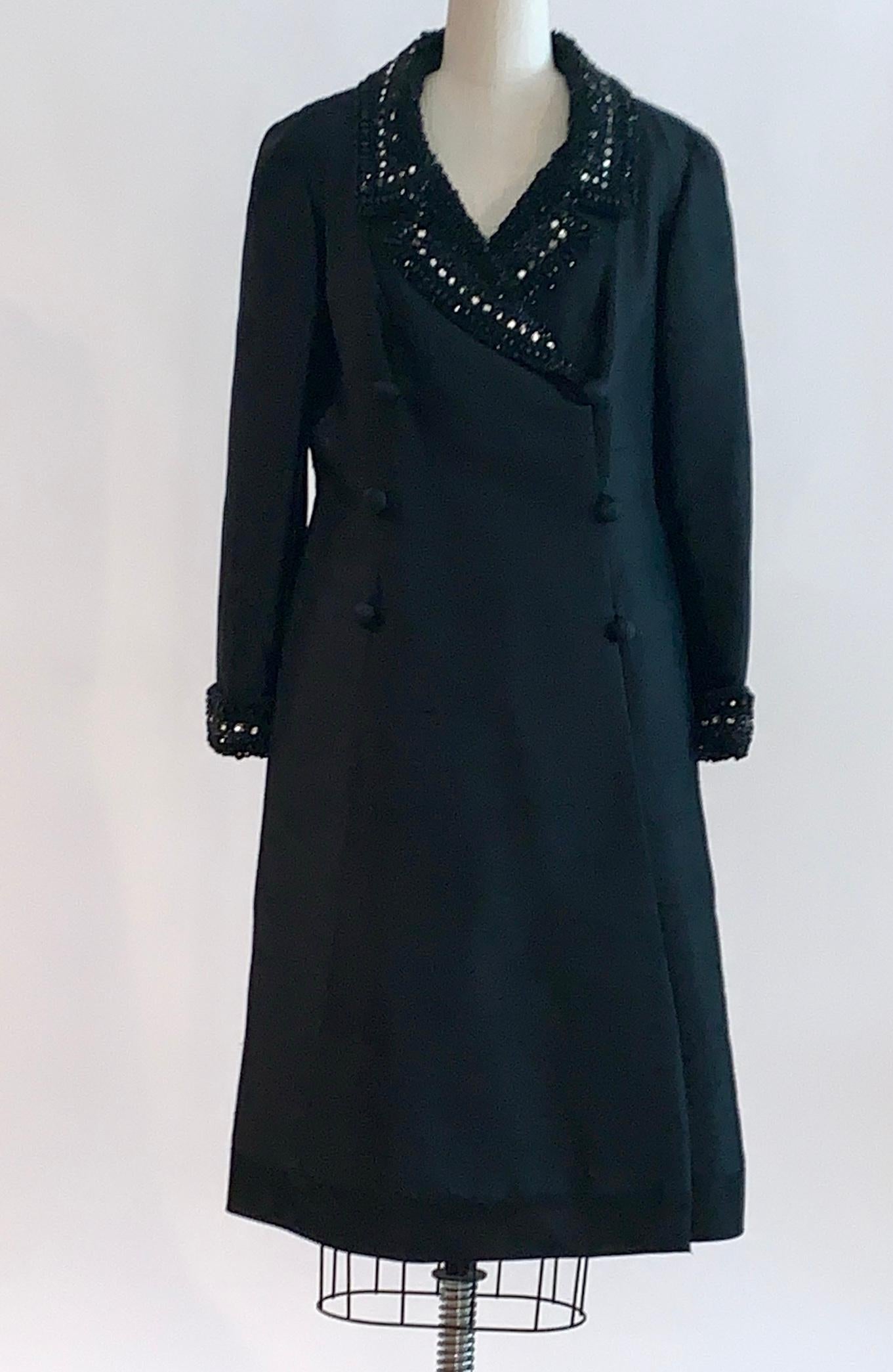 Jean Lutece vintage 1960s black silk double breasted coat (or coat dress) with black rhinestone and seed bead embellishment at collar and cuffs. Raw silk features natural slubbing throughout.  Smooth black trim at bottom. Fastens with an interior