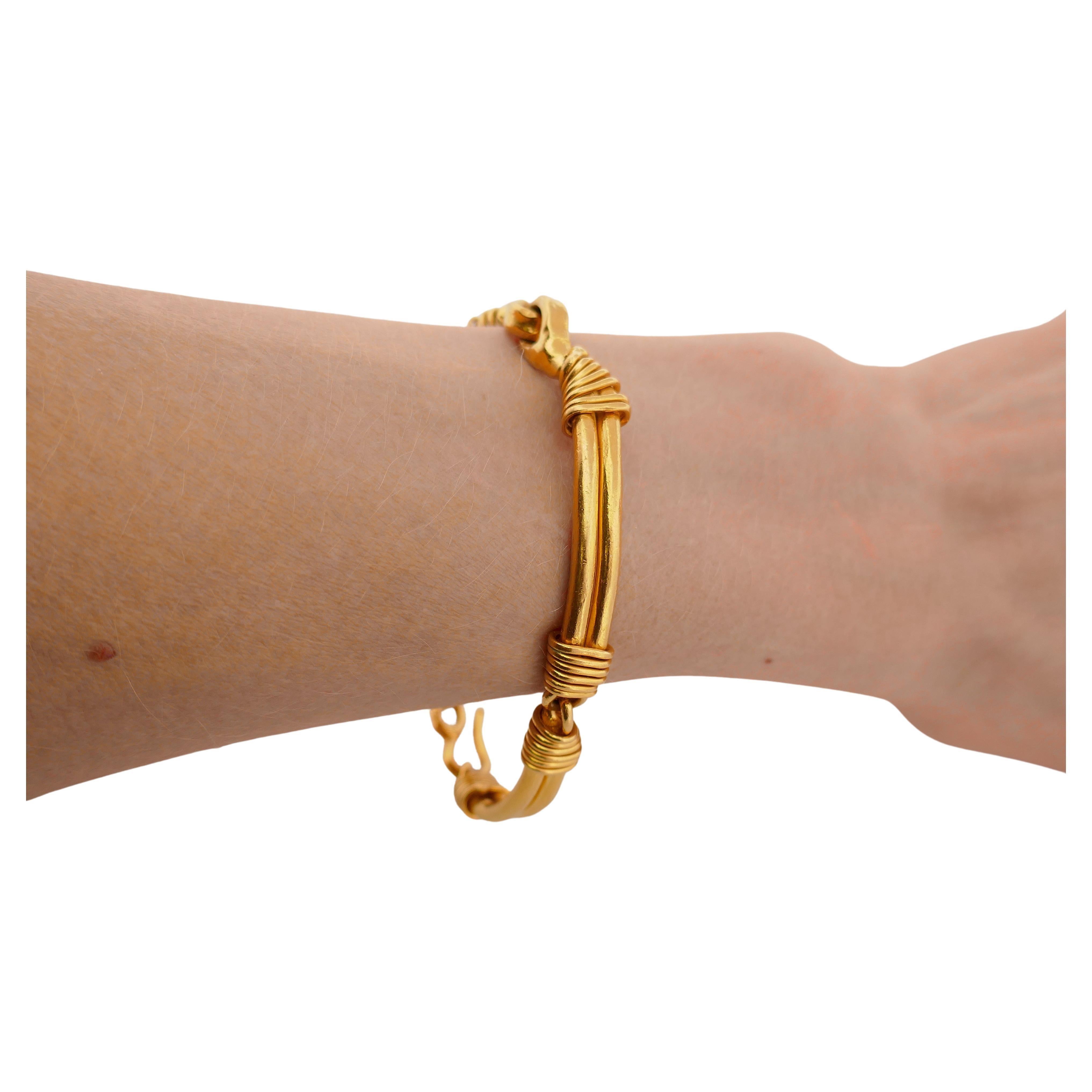 Ein exquisites 22-karätiges Goldarmband von Jean Mahie.
Das Armband ist als Stabgliederarmband mit Schlaufenverbindungen gestaltet. Die Barren sind von unregelmäßiger Größe, die eine Freiheit und spontane Natur der Kunst vermittelt. Die Golddrähte,