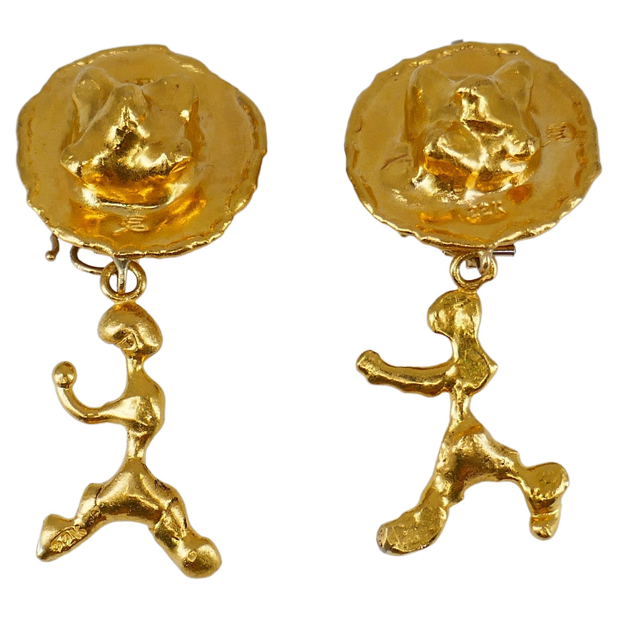 A pair of convertible Jean Mahie earrings made of 22k gold.
The earrings of abstract design comprises two parts: a clip-on circle earring and a dangling figure. The latter can be worn as a charm or pendant. 
These sculptural Mahie earrings with its