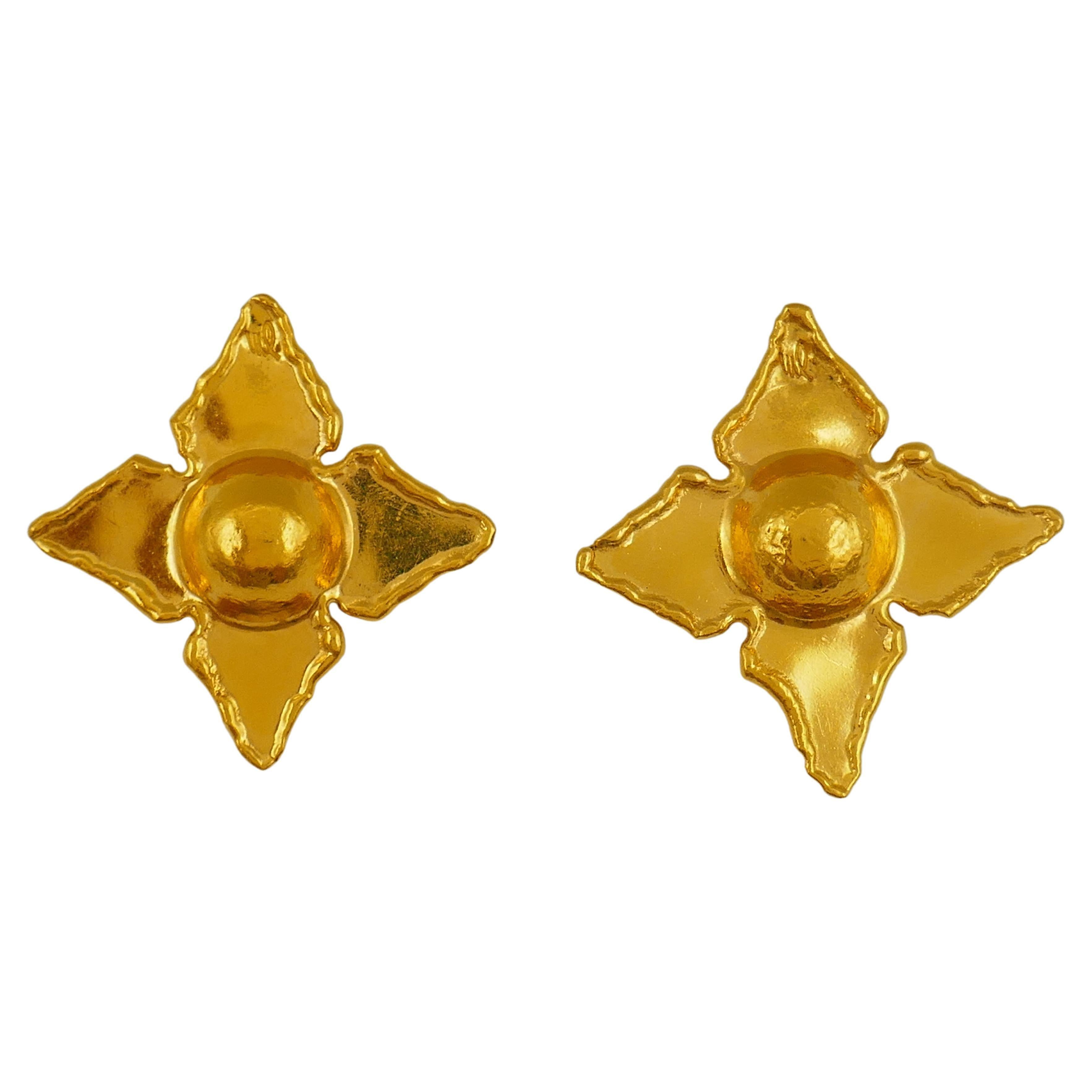 A gorgeous pair of earrings by Jean Mahie, made of 22k gold.
The earrings are designed as starry flowers with a convex center and four flat pointy petals. The hammered petals' edges have a great uneven feel. 
The gold has a distinct Mahie's look and