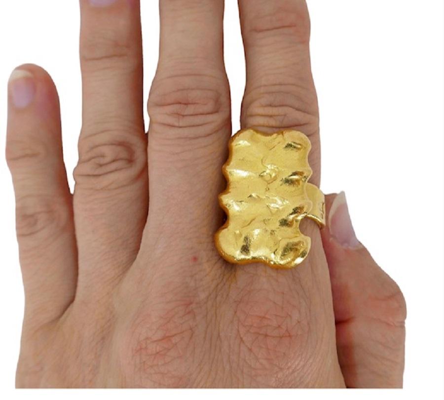 A sculptural ring by Jean Mahie, made of 22k gold. The ring has a gorgeous texture with folds and caves. It seems like the gold is soft and malleable. The band is open, which adds to artisanal look of the ring. This Mahie ring is massive, heavy, and
