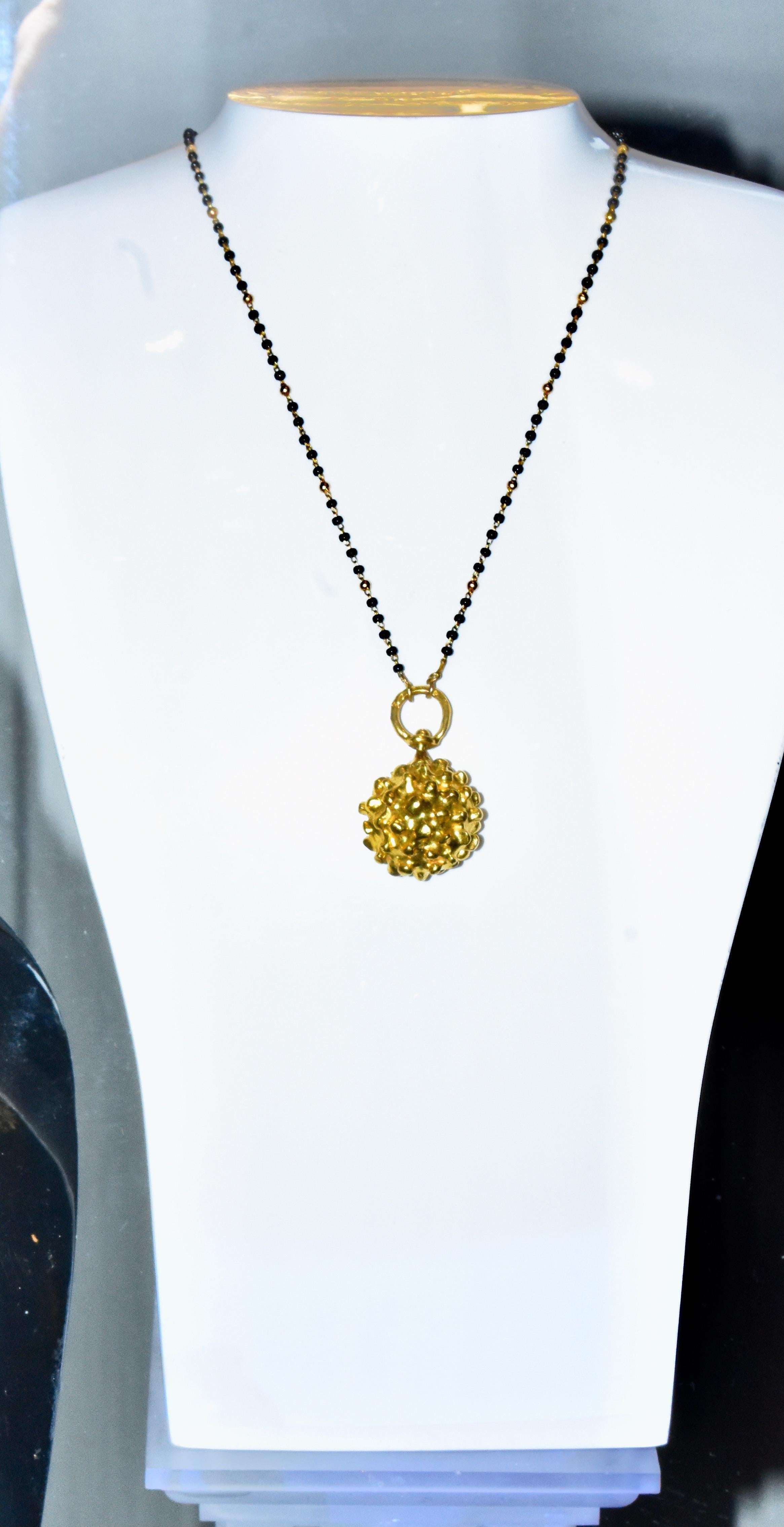 Jean Mahie Etruscan large ball pendant  in 22K yellow gold is very easy to wear and distinctive. Shown here on a contemporary gold chain  with onyx small balls which has a length of 16.5 inches (this chain is not by Jean Mahie). The Etruscan sphere