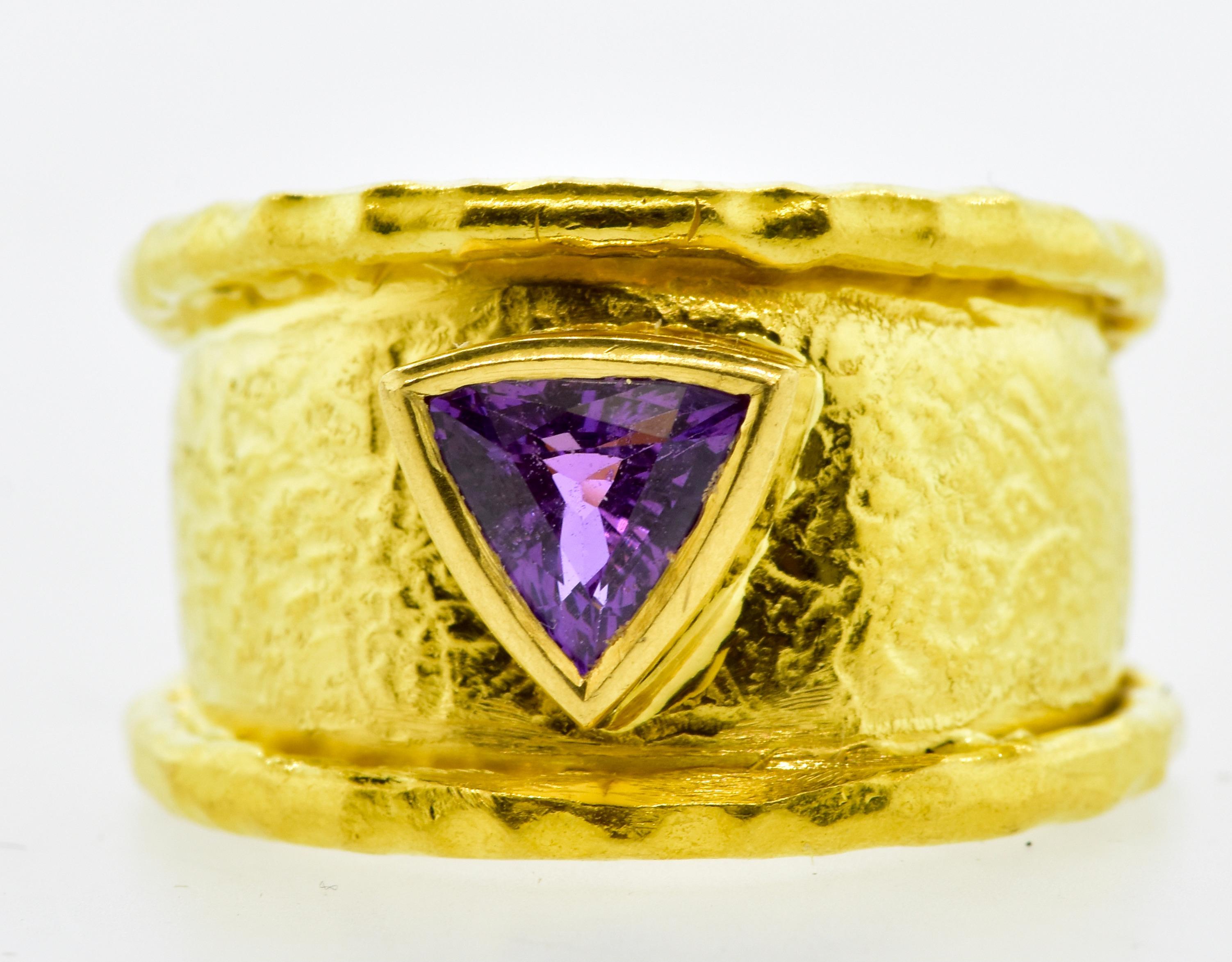Jean Mahie 22K hand made ring centering a fine natural fancy cut purple sapphire. The triangle cut sapphire weighs approximately 1 ct. This hand hammered ring is signed and numbered by the fine French firm Jean Mahie. One can see similar rings on