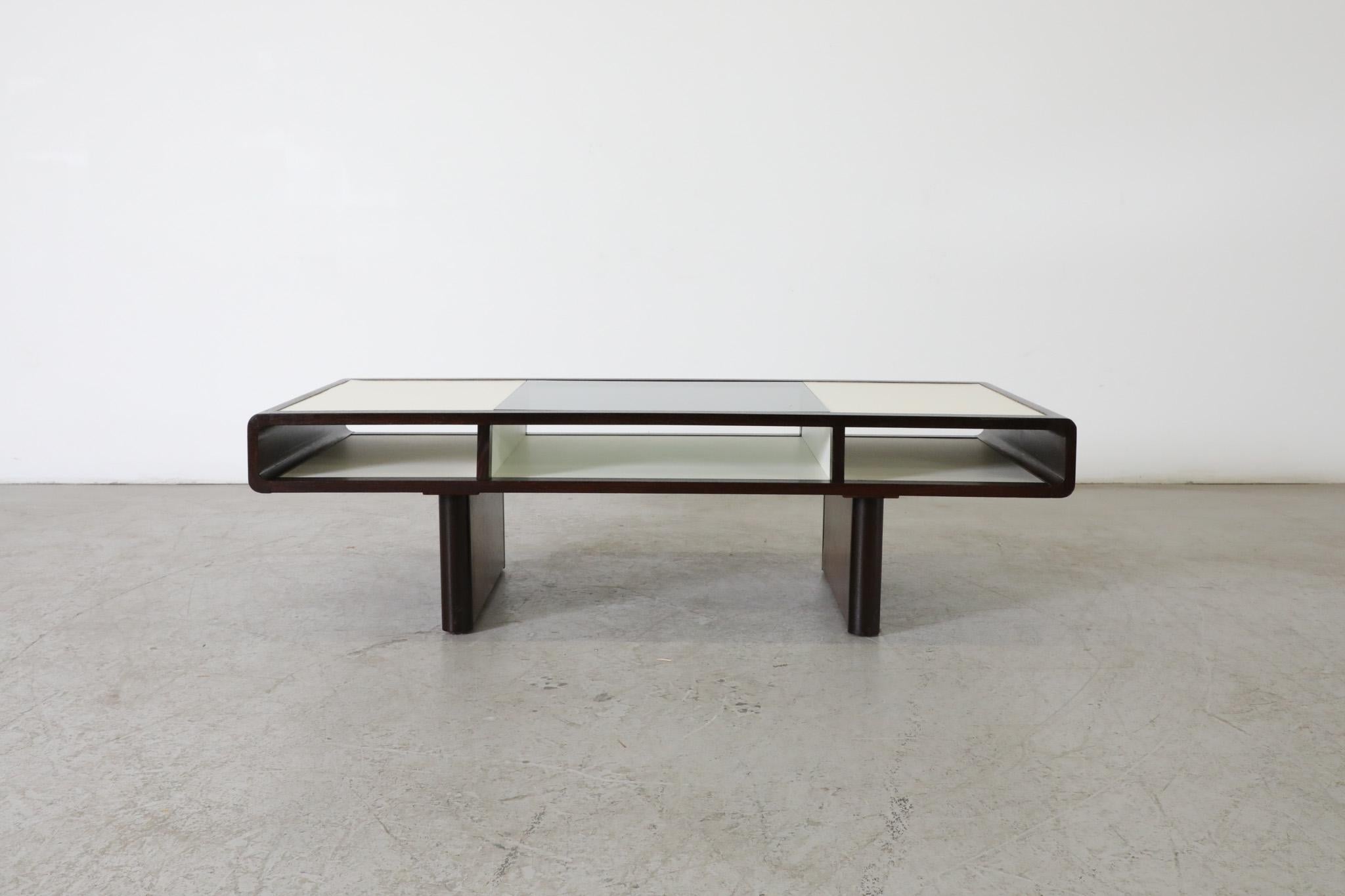 MOD Jean Maneval style wenge coffee table with smoked glass top and formica. An attractive coffee table with graceful curves and wenge legs. Classical balance of style and function with complimentary materials and large storage compartments perfect