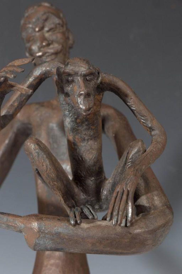 Jean Marc manner bronze sculpture of an elongated man holding a monkey, circa 1961. 