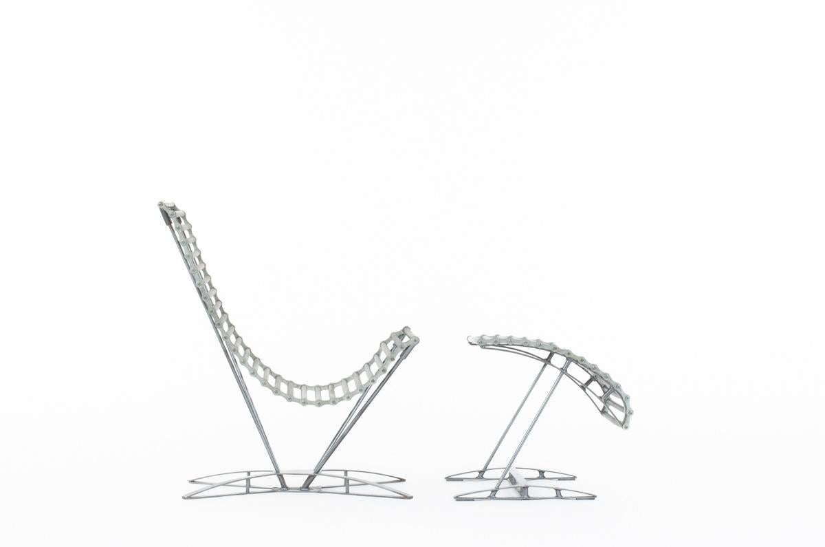 Armchair and footstool called rocking chaine produced in 1993 in Paris designed by Jean-marc Mouligne edited by Quart de poil. 
Very rare model, consists of a base with 2 chains connected by elastic crosspieces cover with rubber tubing. It provides