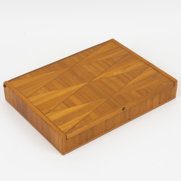 Elegant straw marquetry decorative lidded box designed by Jean Michel Frank (1895 - 1941). Long rectangular shape, with a refined geometric design, interior in cork. No visible maker's mark.
Measurements: 6.88 in. long (17.5 cm) x 5.13 in. wide (13