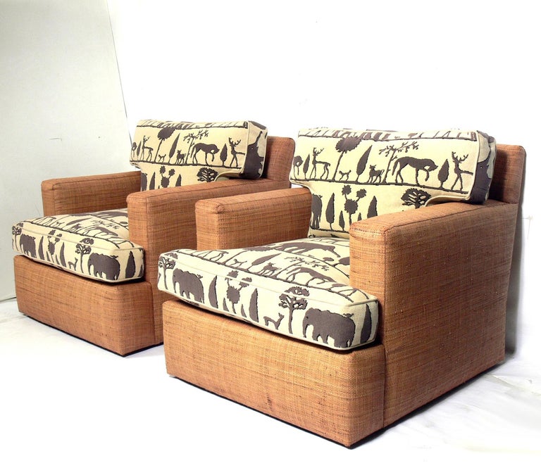 Pair of lounge chairs in the style of Jean Michel Frank Design, circa 1990s. They are upholstered in Giacometti Zoo fabric by Clarence House. They are a substantial large scale design. They retain their warm original patina.