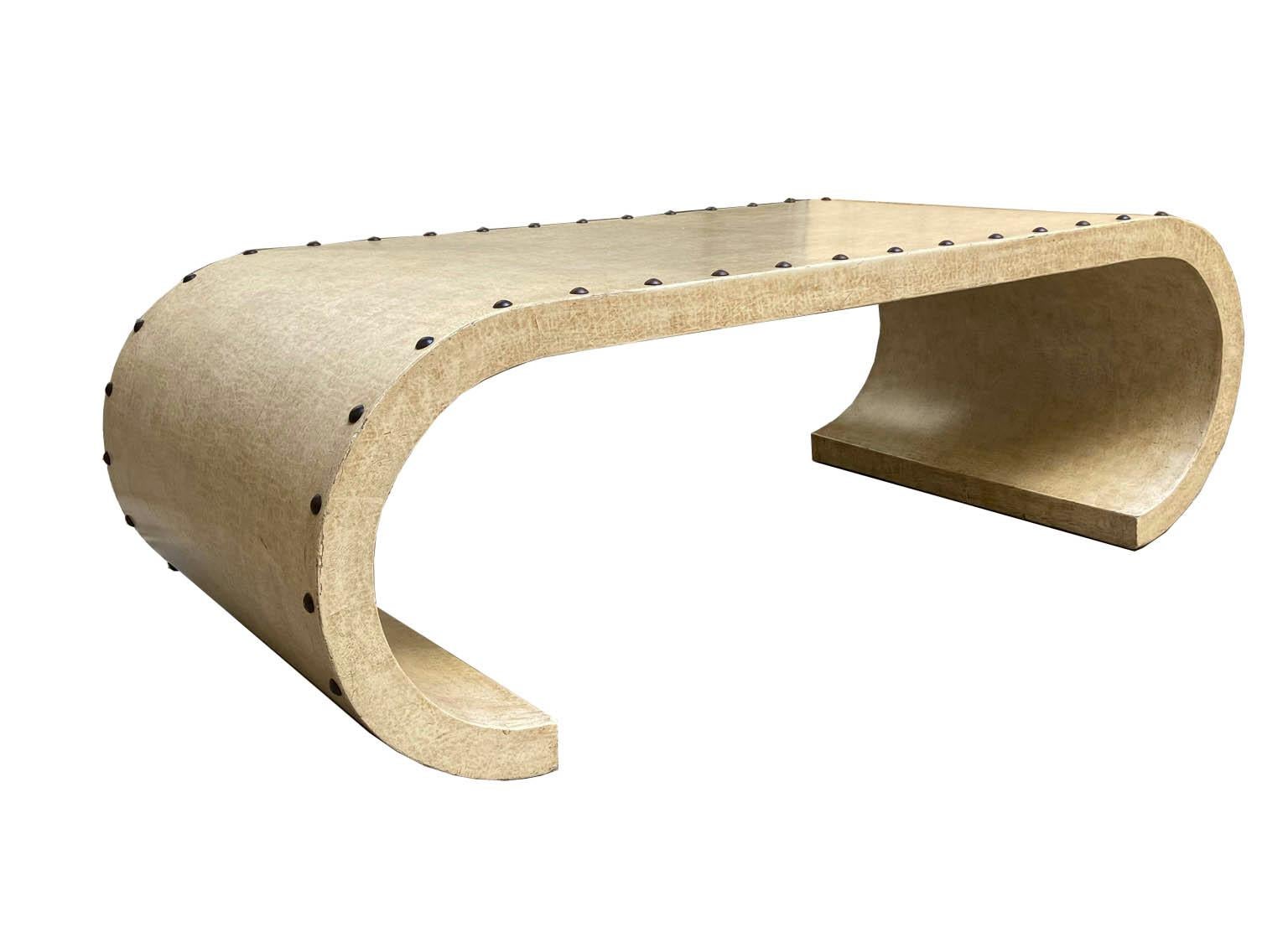 Beautiful coffee table made of wood covered in goatskin parchment, with brass studs.