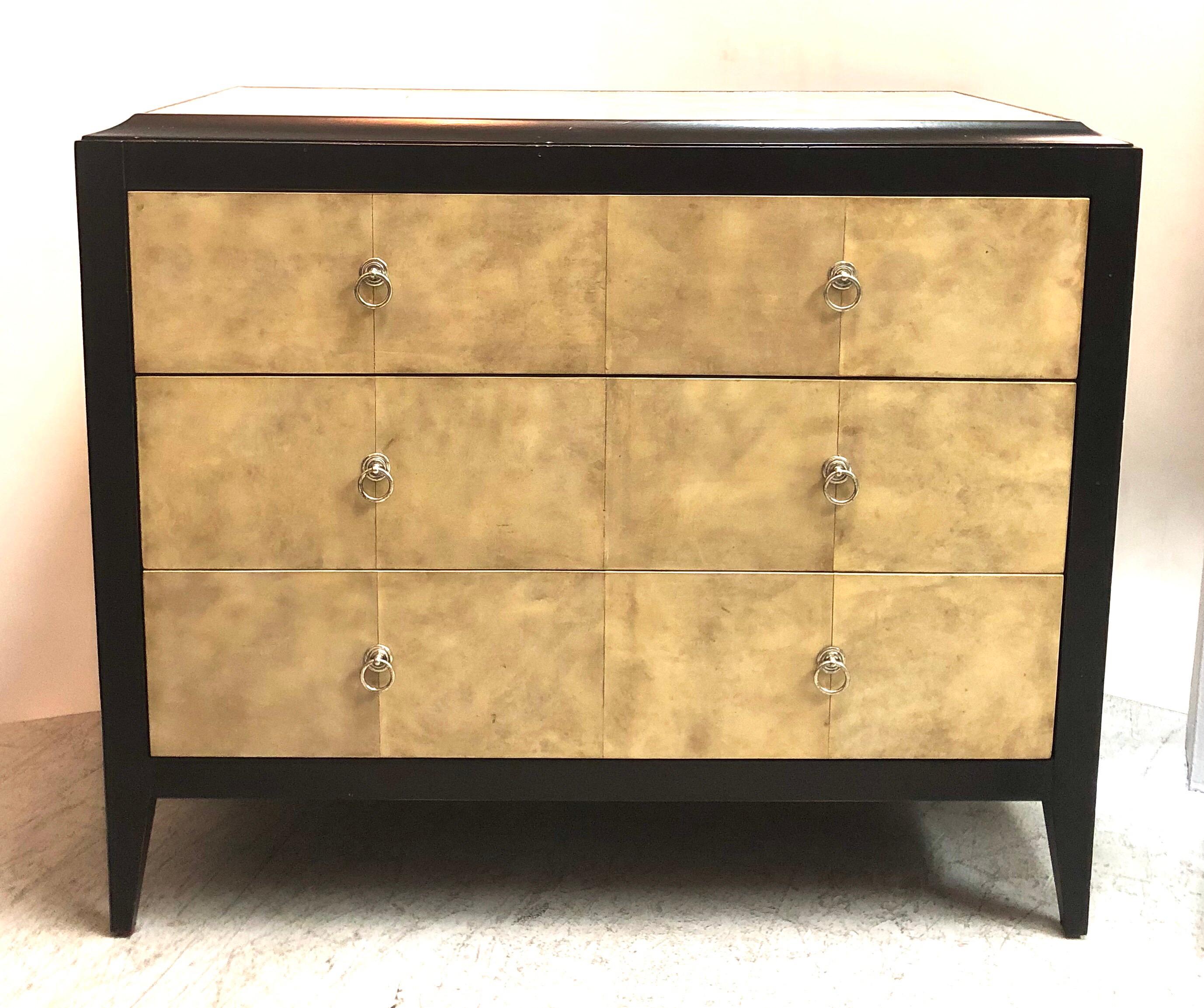 A wood and parchment chest of drawers after a design by Jean Michel Frank. The wood frame is ebonized with light distressing effects. Silver ring pulls. Ample storage.
