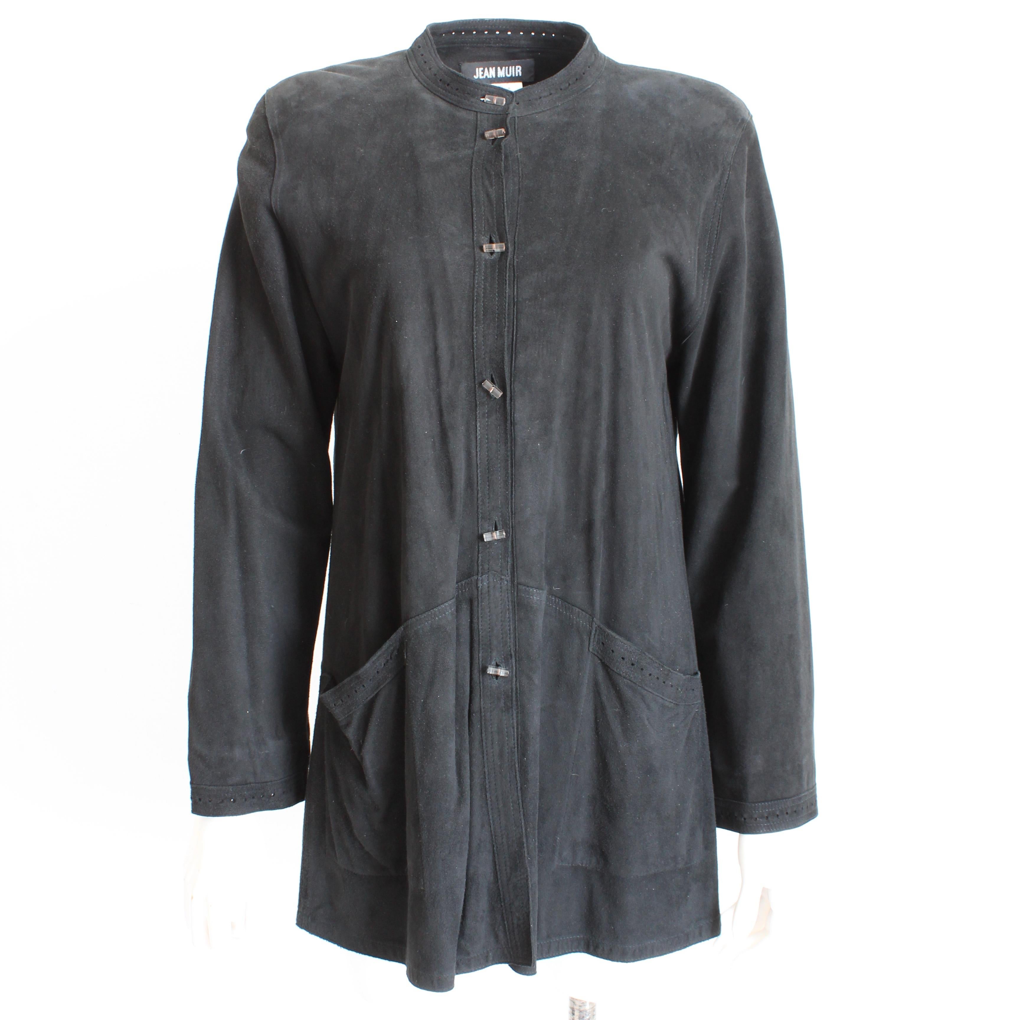 Cette veste en daim noir d'une incroyable souplesse a été conçue par Jean Muir à la fin des années 1970.  Confectionné en cuir suédé noir, il se ferme à l'aide de boutons cylindriques en lucite et présente une bordure perforée au niveau du col, des