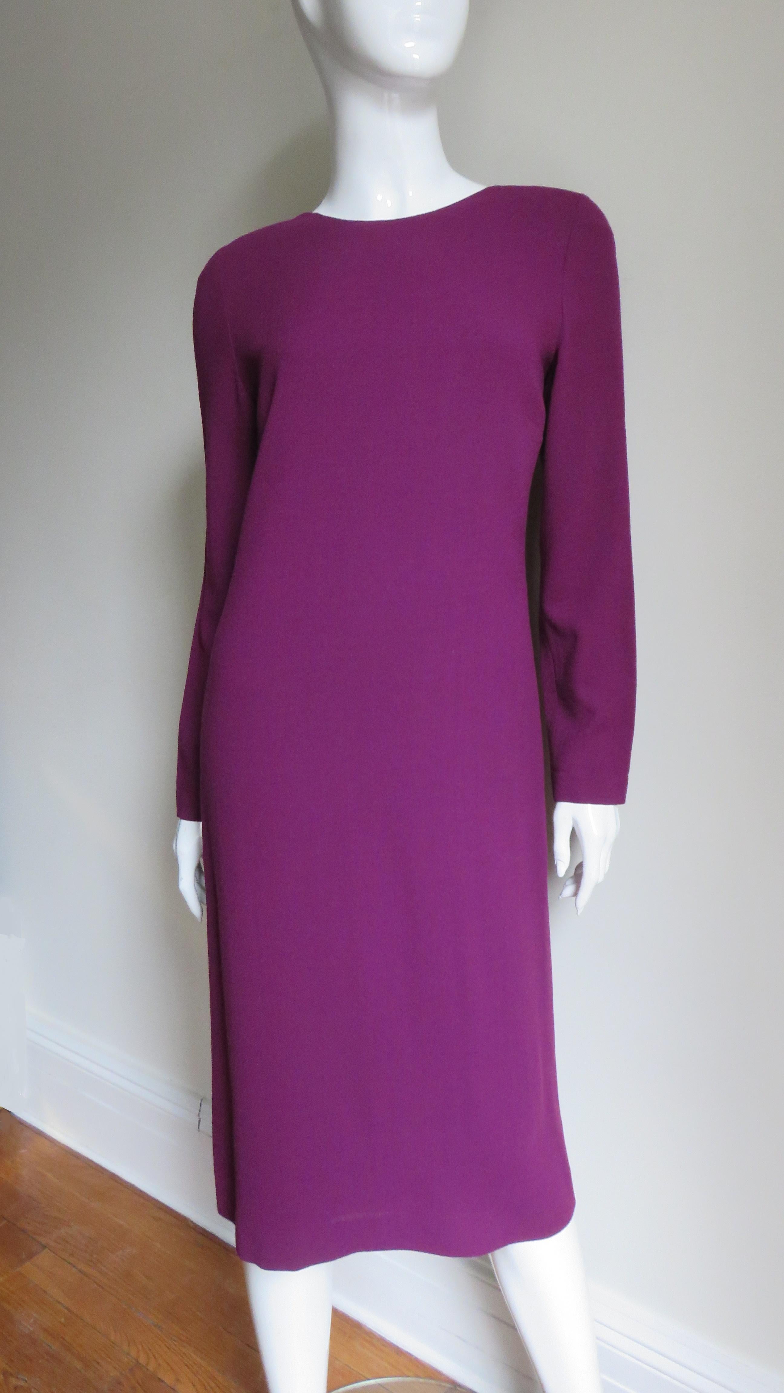 A beautiful deep magenta purple wool dress and coat set by Jean Muir.  The subtle A line dress has a crew neckline and long sleeves.  The matching coat has a lapel collar, small shoulder pads and geometric seaming.  The dress is lined in matching