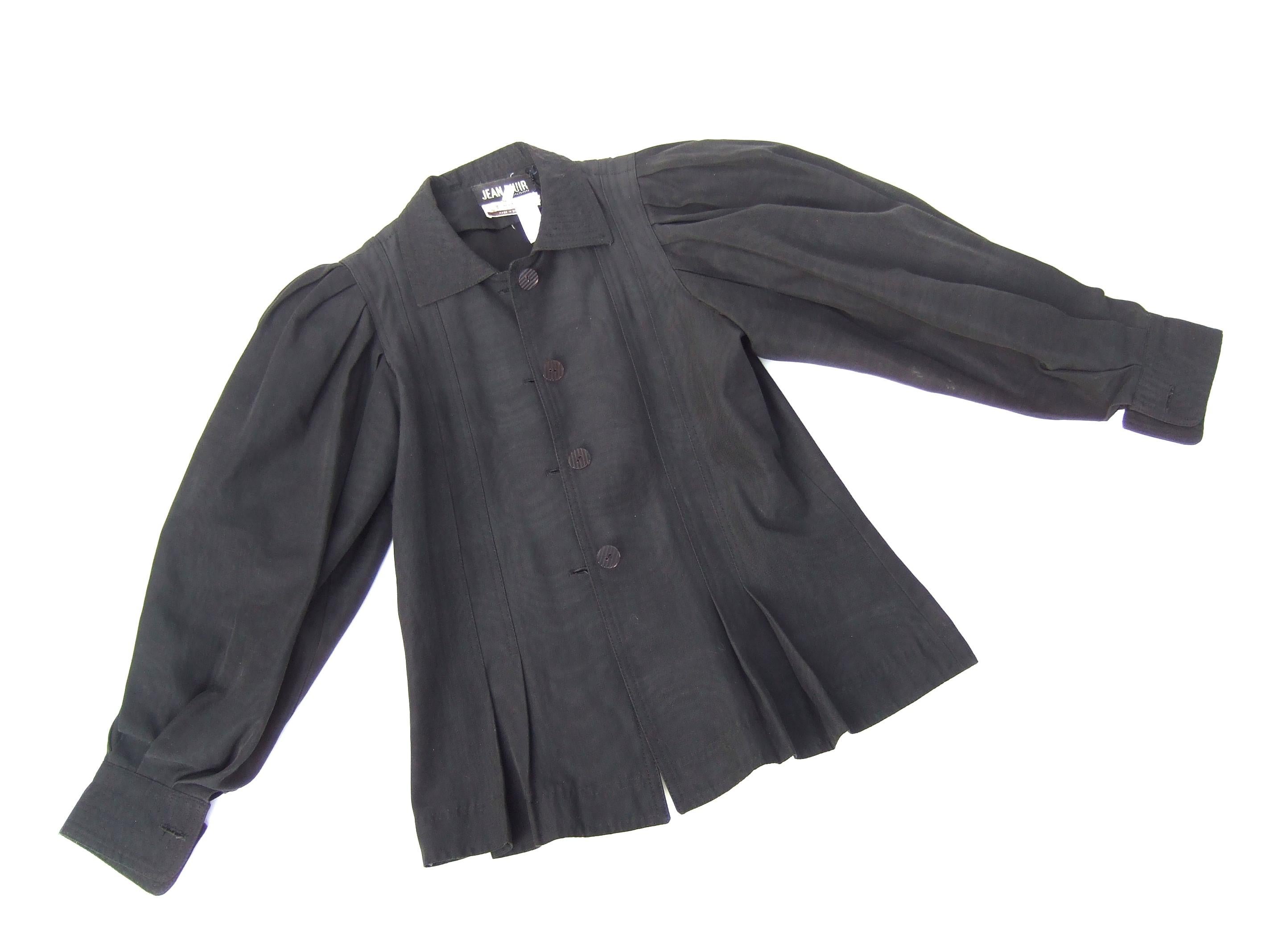 Jean Muir London Black fitted jacket for Neiman-Marcus - 1970s
The unique rayon and cotton blend jacket is designed with voluminous pleated sleeves. Designed with pleated detail on the lower front and back center hemline
that creates a slight peplum