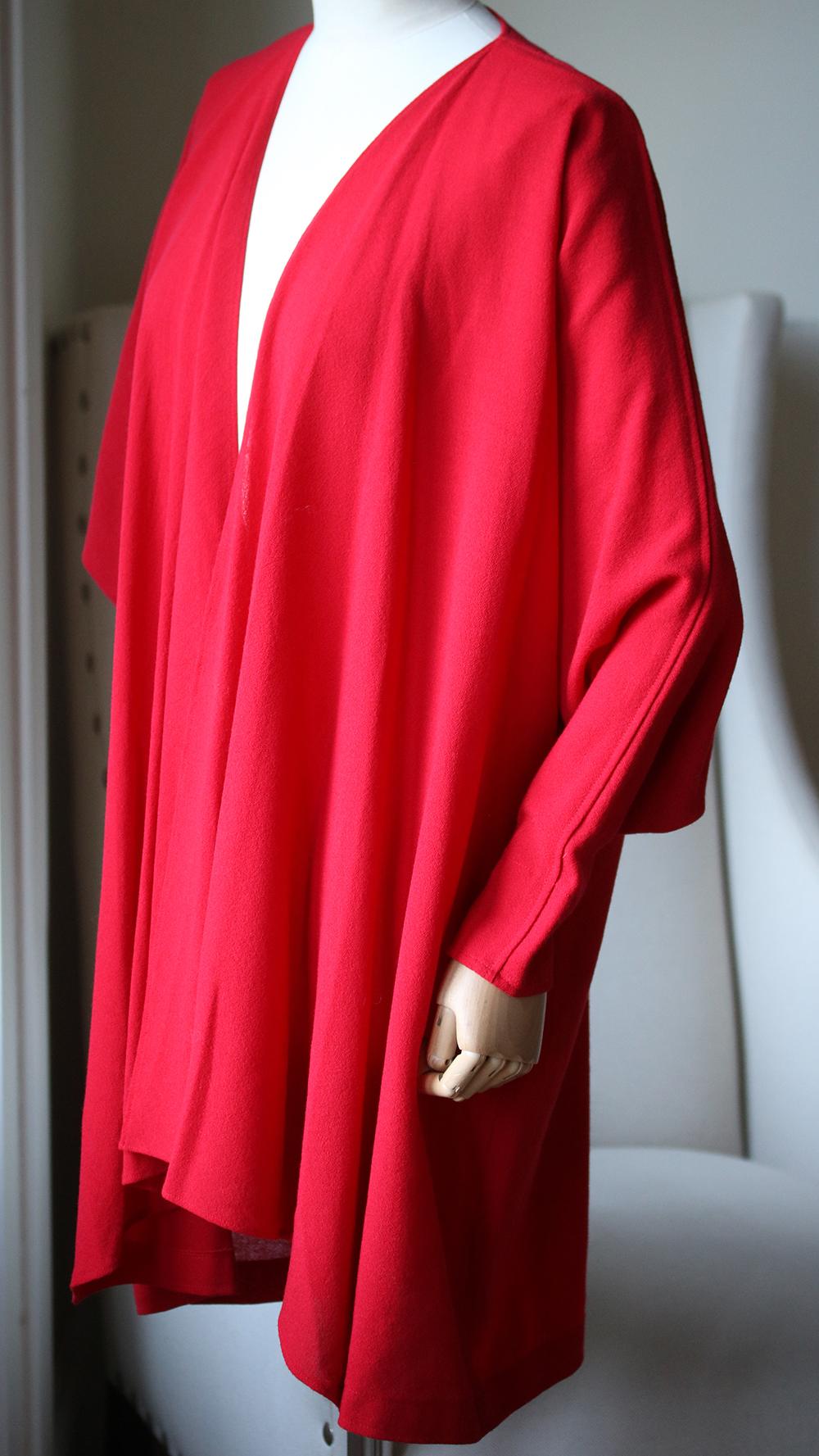 Lovely vintage piece from Jean Muir, an iconic, collectible designer. The finest crepe in bright red, with draping front detail, wide cuff, hanging to the hips. Simple tailoring that has stunning details. 100% Viscose.

Size: UK 10 (US 6, FR 38, IT